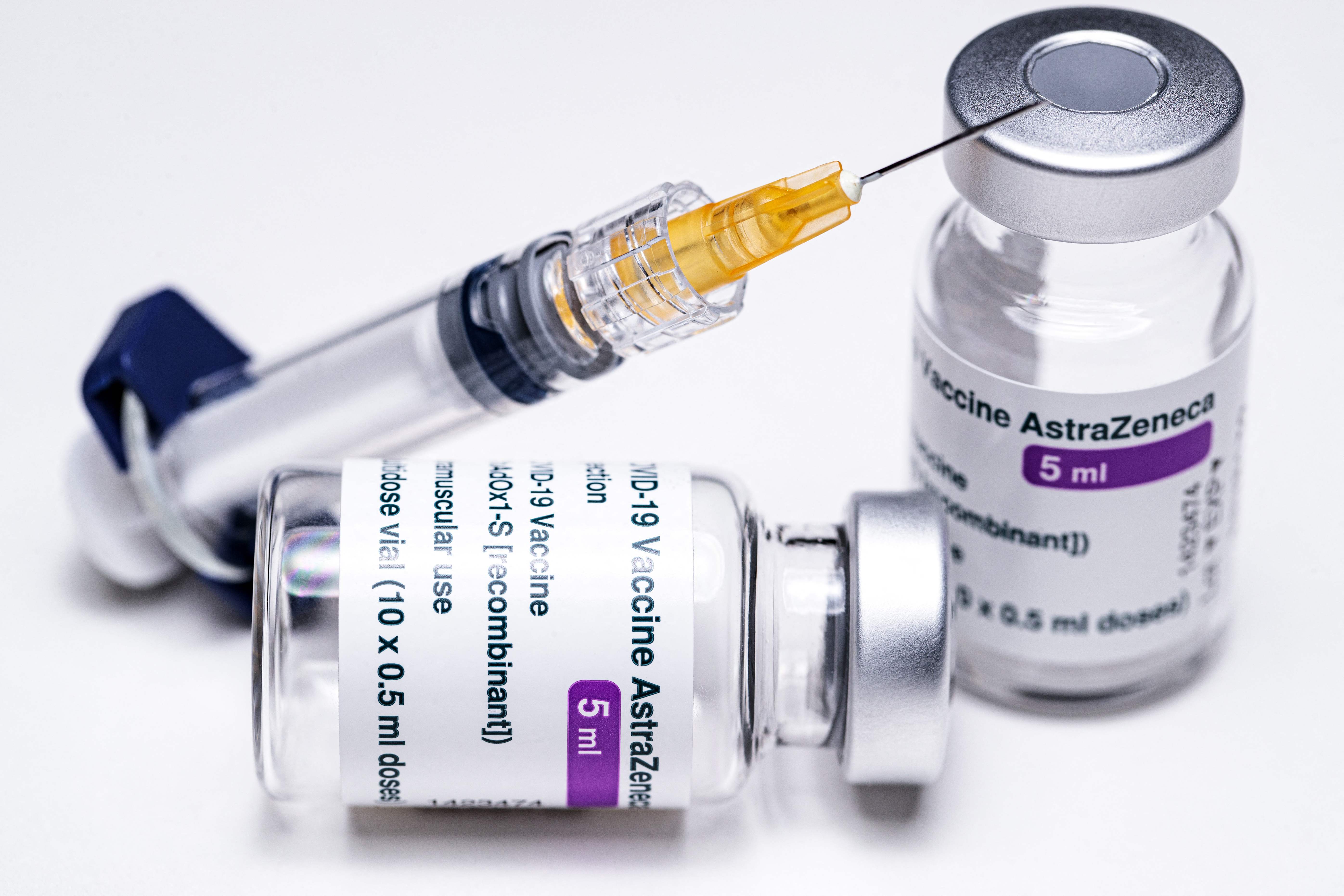 (FILES) This file illustration picture shows vials of the AstraZeneca Covid-19 vaccine and a syringe in Paris on March 11, 2021. - A growing list of countries have suspended AstraZeneca's Covid-19 shots amid fears over blood clots and other possible side effects, despite the company and the World Health Organization insisting there is no risk. (Photo by JOEL SAGET / AFP)