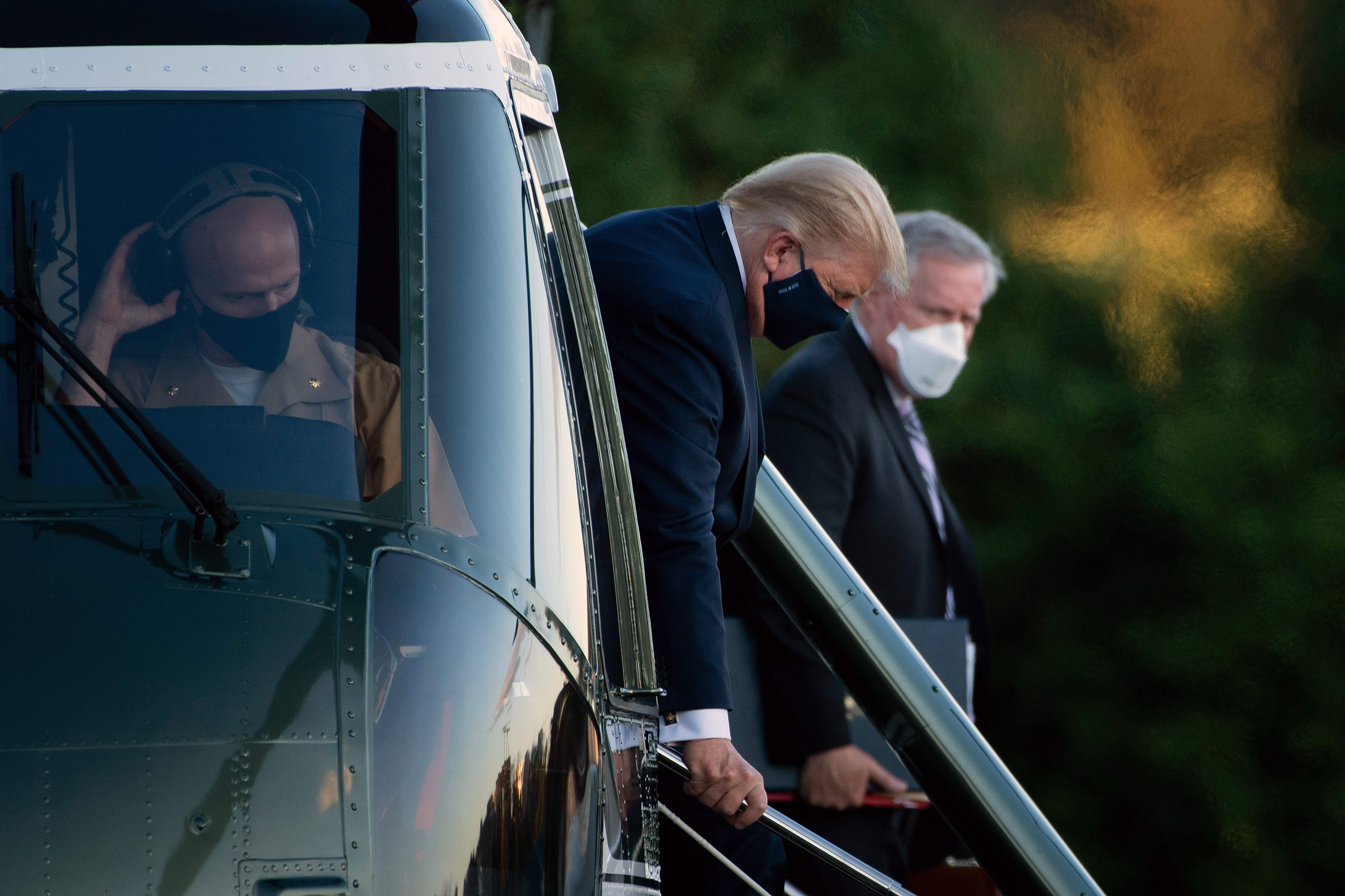 White House Chief of Staff Mark Meadows (R) watches as US President Donald Trump walks off Marine One while arriving at Walter Reed Medical Center in Bethesda, Maryland on October 2, 2020, after testing positive for covid-19. - President Donald Trump will spend the coming days in a military hospital just outside Washington to undergo treatment for the coronavirus, but will continue to work, the White House said Friday (Photo by Brendan Smialowski / AFP)