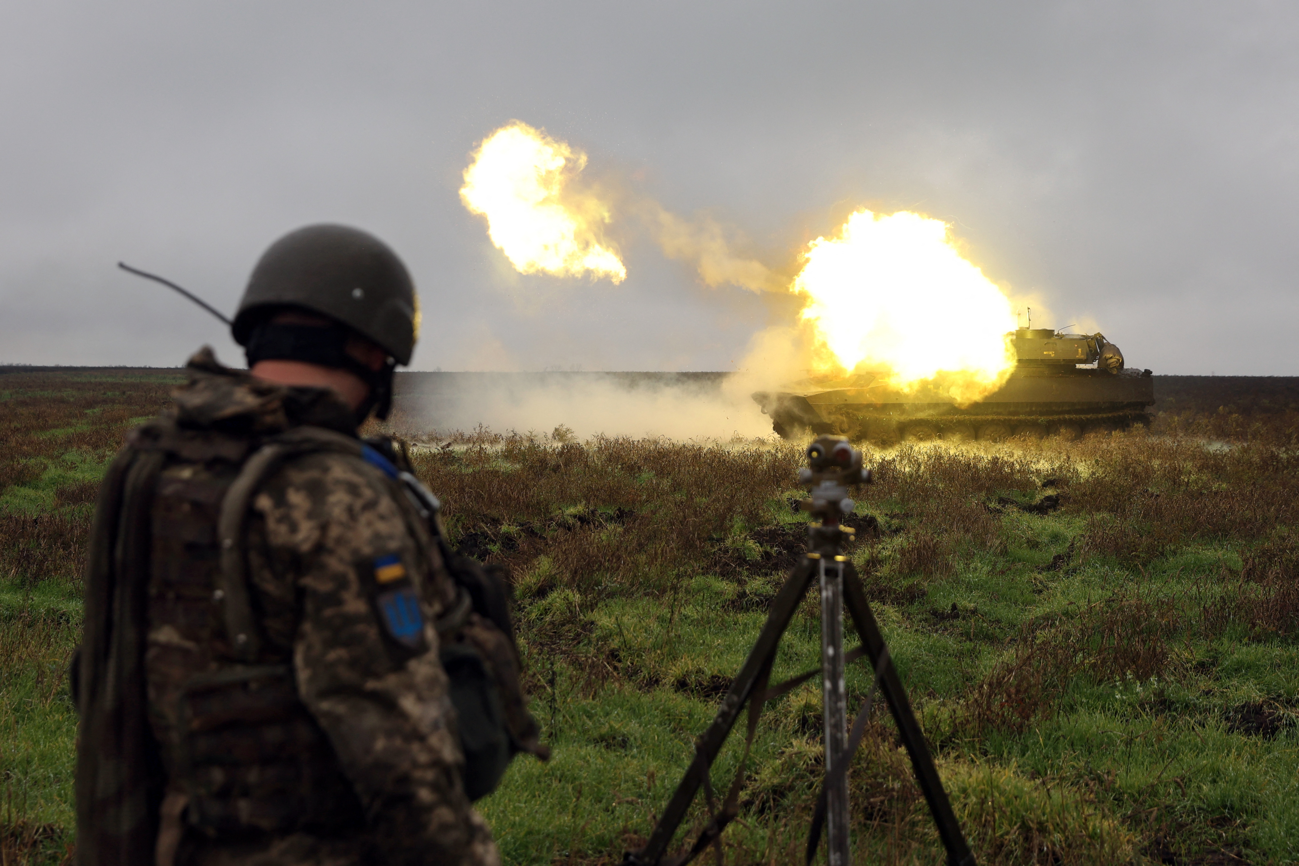A Ukrainian soldier stands as a 2S1 Gvozdika self-propelled howitzer fires a shell on the front line in Donetsk region on October 10, 2022 as Russian forces launched earlier today at least 75 missiles at Ukraine, with fatal strikes targeting the capital Kyiv, and cities in the south and west. (Photo by Anatolii STEPANOV / AFP)