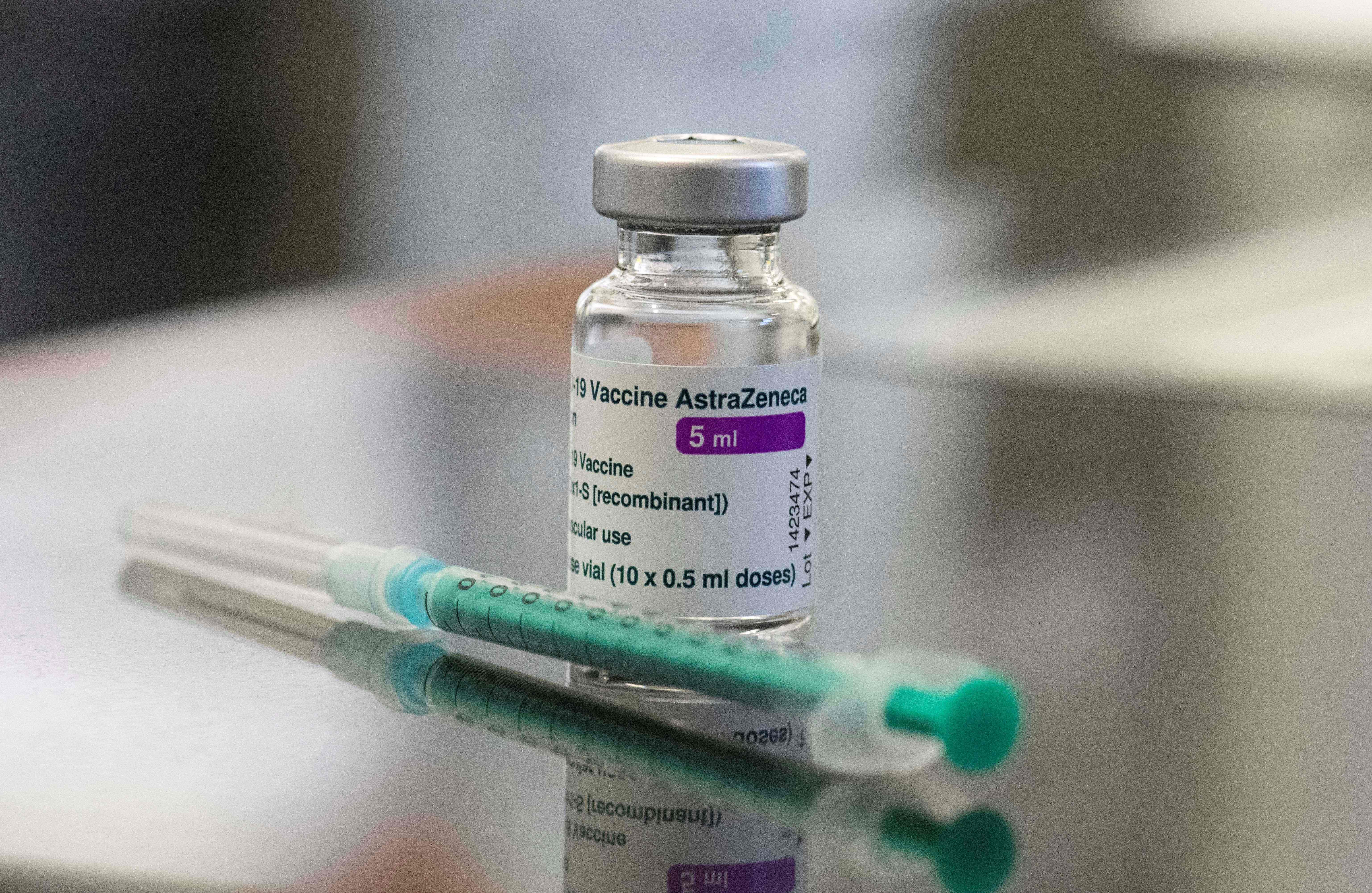 (FILES) A file photo taken on February 12, 2021 shows a vial containing the Covid-19 vaccine by AstraZeneca and a syringe displayed on a table in the pharmacy of the vaccination center at the Robert Bosch hospital in Stuttgart, southern Germany. - The World Health Organization gave emergency use approval to AstraZeneca's Covid-19 vaccines on February 15, 2021, allowing distribution to some of the world's poorest countries to begin. "The WHO today listed two versions of the AstraZeneca-Oxford Covid-19 vaccine for emergency use, giving the green light for these vaccines to be rolled out globally through Covax," a WHO statement said, referring to the programme aimed at equitable distribution of inoculations. (Photo by THOMAS KIENZLE / AFP)