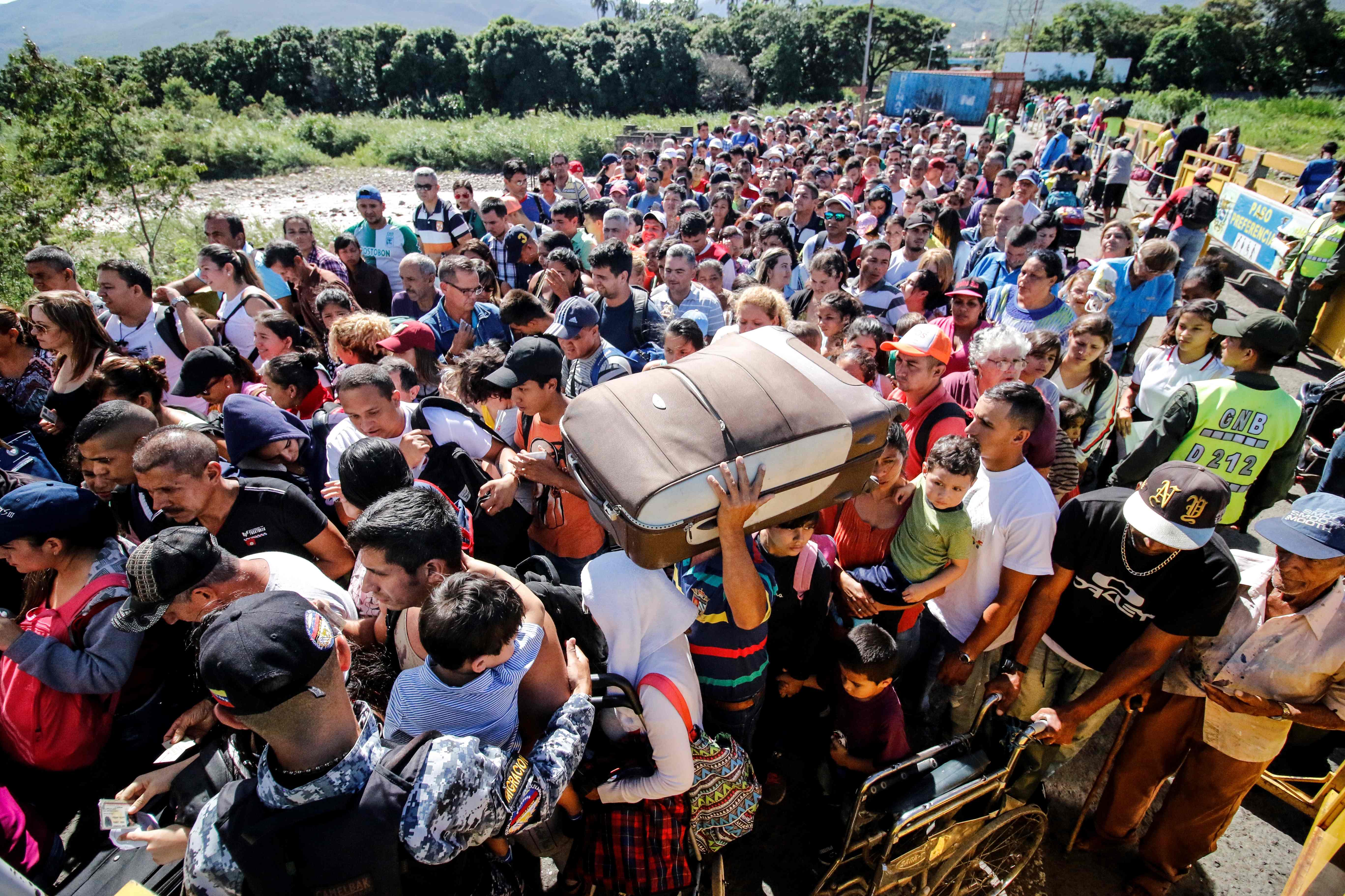People queue to cross the Simon Bolivar international bridge from San Antonio del Tachira in Venezuela to Cucuta, in Colombia, to buy goods due to supplies shortage in their country, on June 8, 2019. - Venezuela's President Nicolas Maduro on Friday ordered the reopening of the country's border with Colombia in western Tachira state, near where international aid refused by Caracas has been amassed. (Photo by Schneyder MENDOZA / AFP)