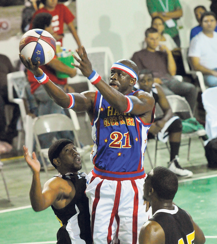 Special K salta entre dos defensores del equipo Washington Generals para encestar uno de los tantos espectaculares puntos que hizo. | CARLOS BORBÓN