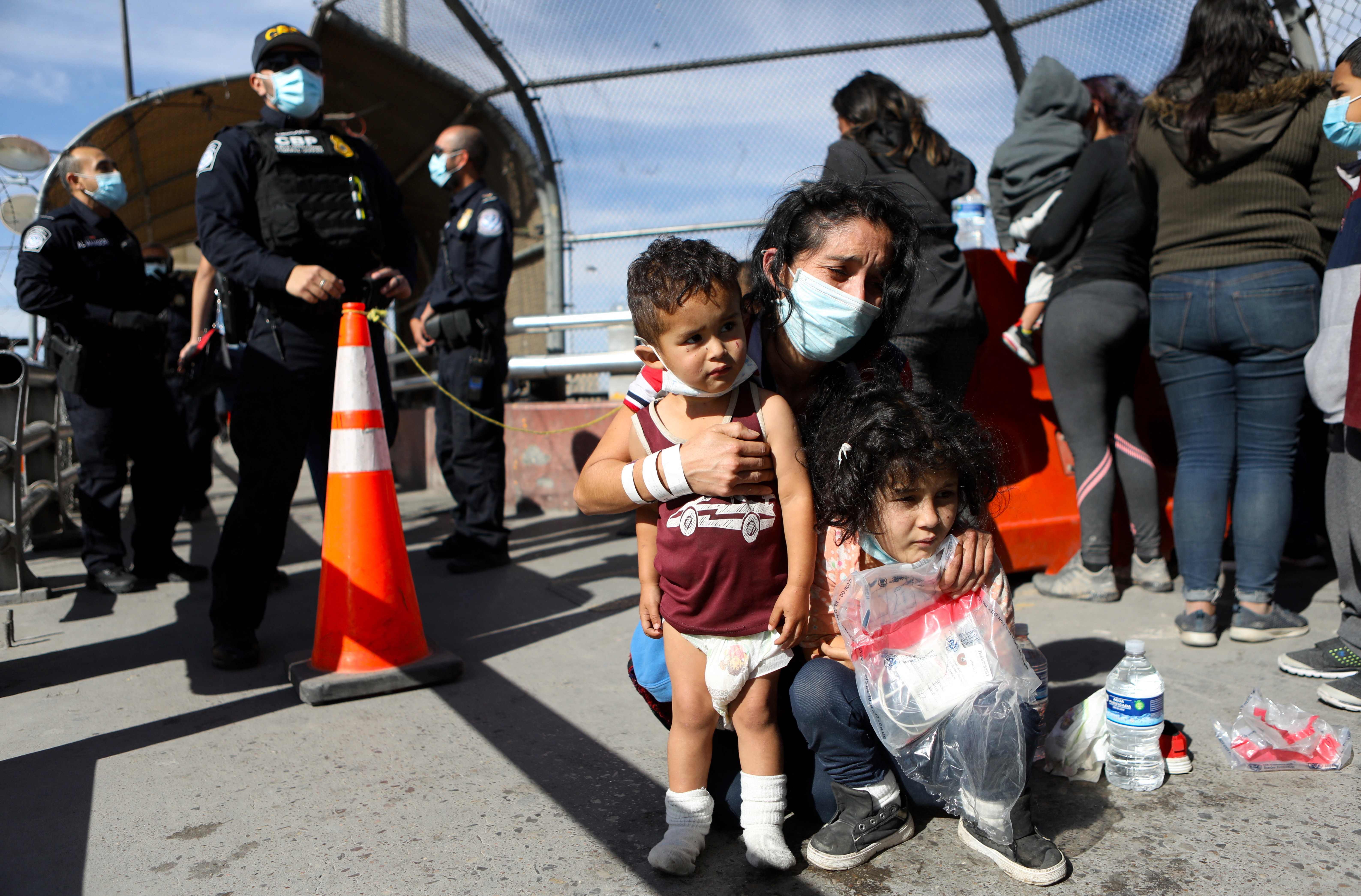 TOPSHOT - Dozens of Central American migrants are expelled from the United States by the Paso del Norte-Santa Fe international bridge, from El Paso, Texas, United States to Ciudad Juarez, state of Chihuahua, Mexico, on March 18, 2021 (Photo by HERIKA MARTINEZ / AFP)
