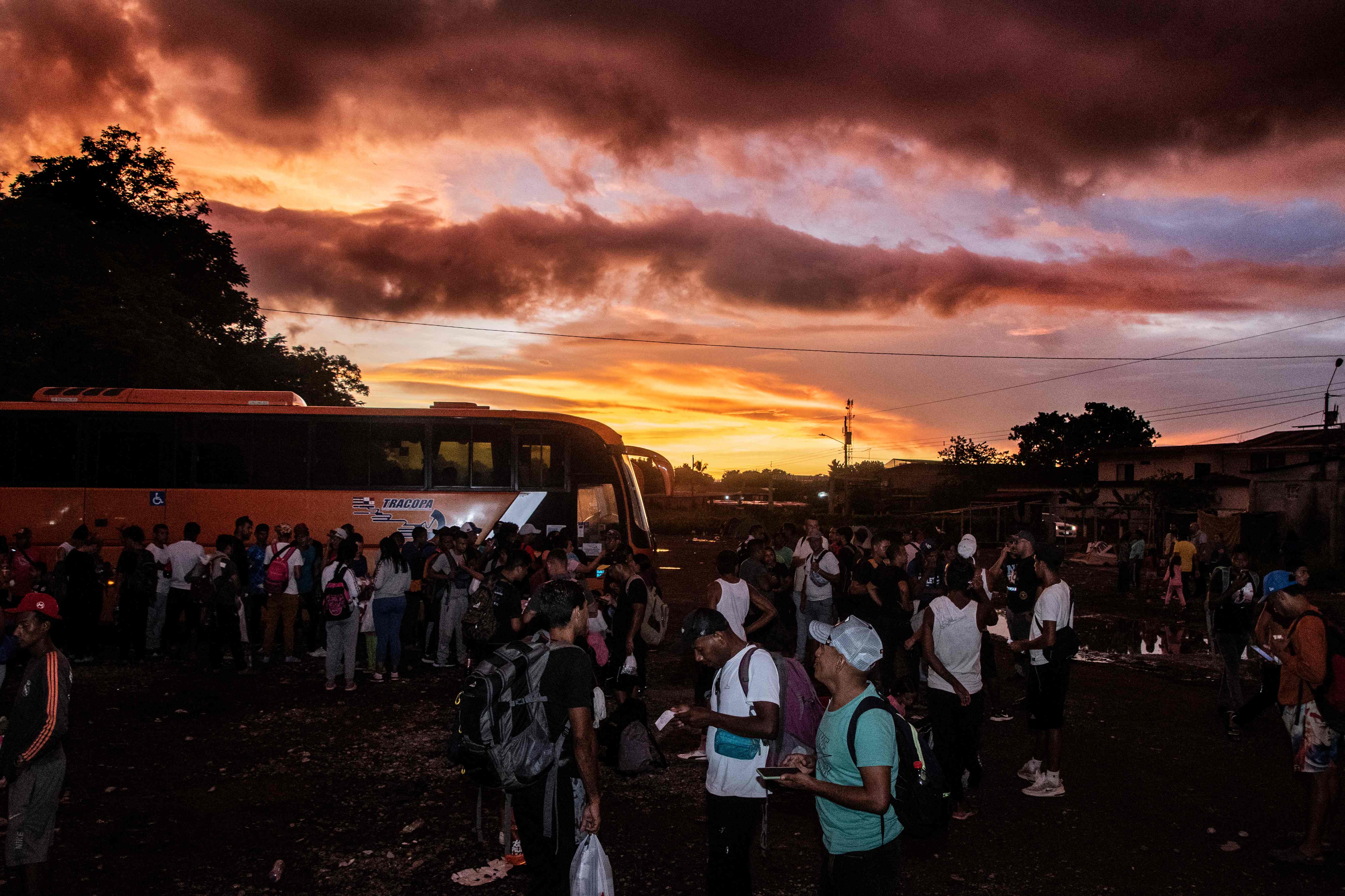 TOPSHOT - Venezuelan migrant wait to board a bus that will take them to the Nicaraguan border at the Paso Canoas refugee camp in Puntarenas, Costa Rica on August 9, 2023. Paso Canoas, the main border crossing between Panama and Costa Rica, has become a crossroads for migrants: those with money stay only a few hours there, and those without see their "American dream" turn into a "nightmare". (Photo by Ezequiel BECERRA / AFP)