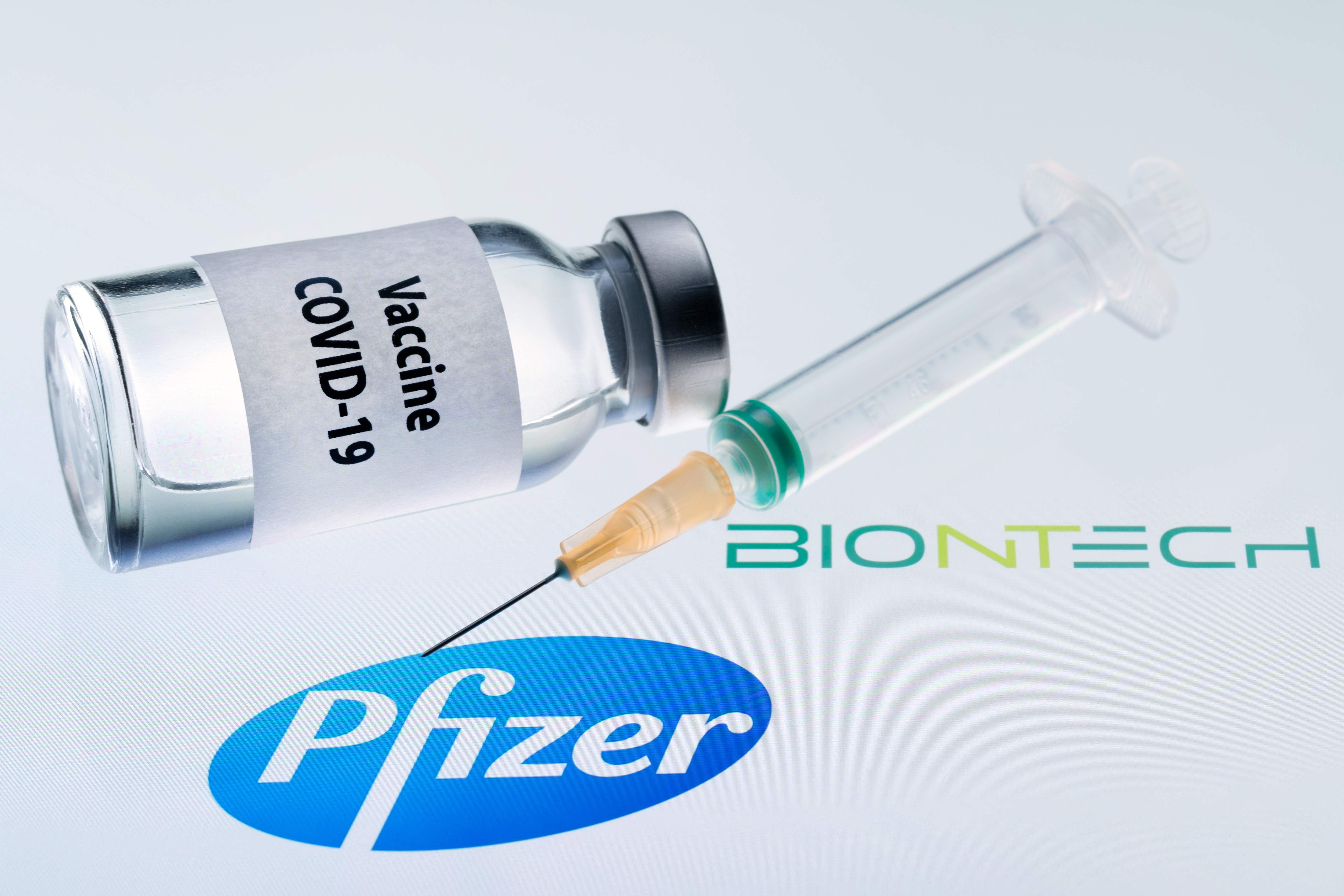 Esta ilustración de archivo tomada el 23 de noviembre de 2020 en París muestra una vacuna contra la COVID-19 y una jeringa junto a los logotipos de Pfizer y Biontech. Fotografía: AFP.