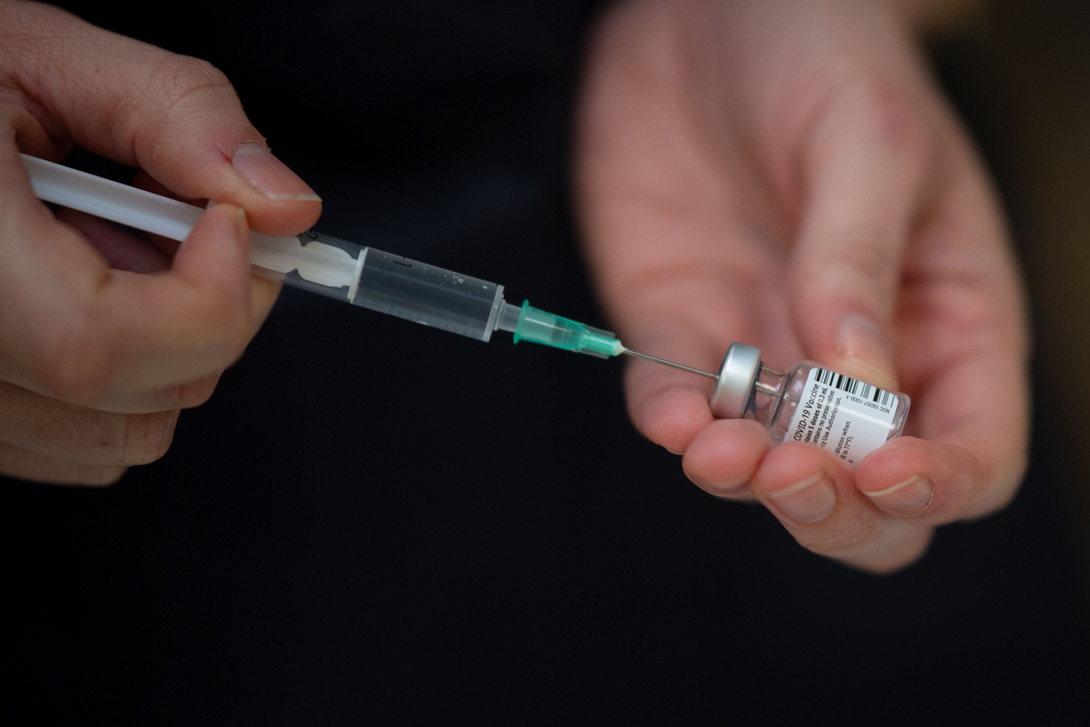 A healthcare worker prepares a Pfizer-BioNtech vaccine at a vaccination centre in Nantes, western France on January 18, 2021, during a Covid-19 vaccination campaign for people over 75. (Photo by LOIC VENANCE / AFP)