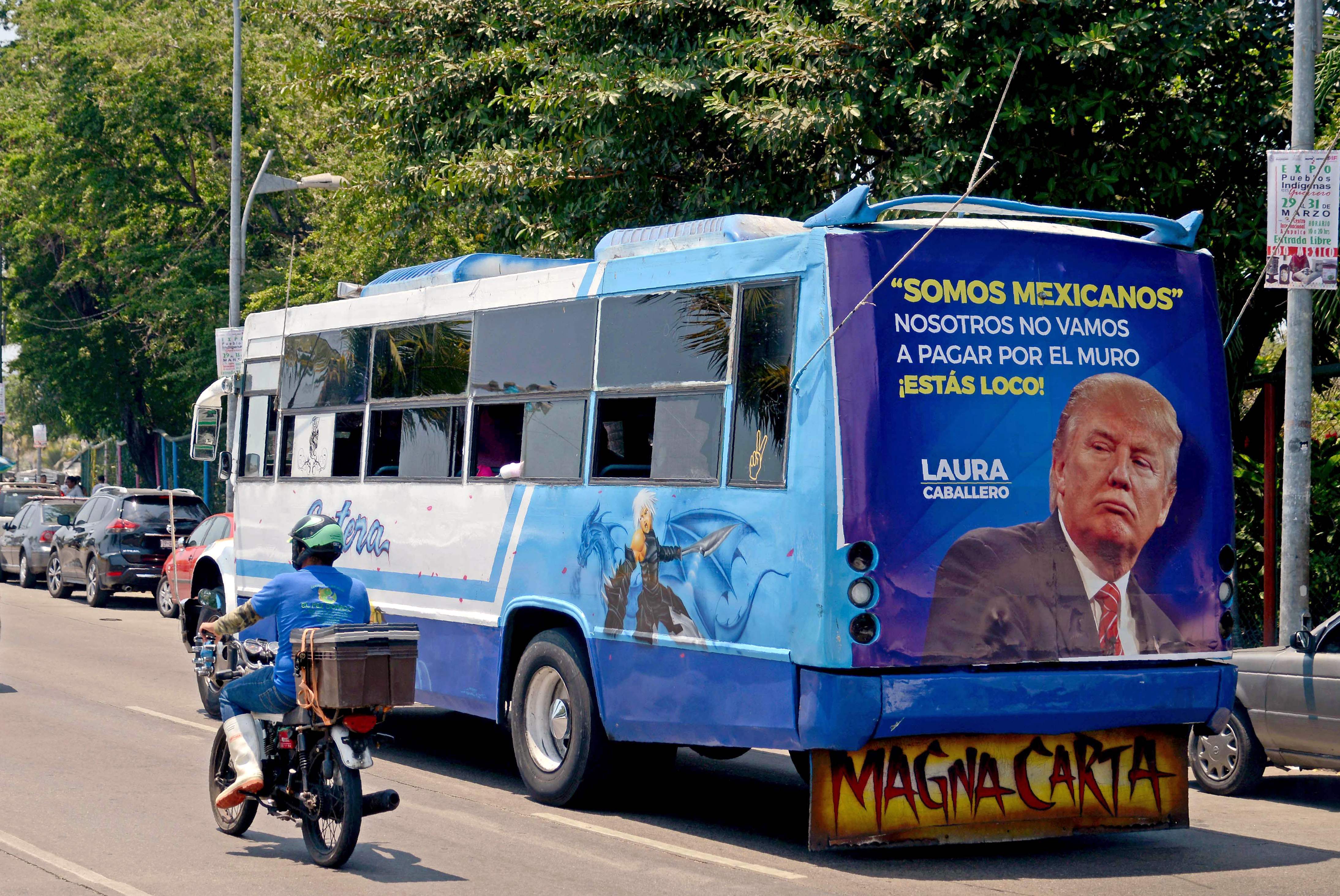 Un autobús circula por las calles de la ciudad de Acapulco, en el estado de Guerrero, México con una pancarta y la imagen del presidente estadounidense Donald Trump con una leyenda que dice "somos mexicanos. No pagaremos el muro. ¿Estás loco?", el 31 de marzo.