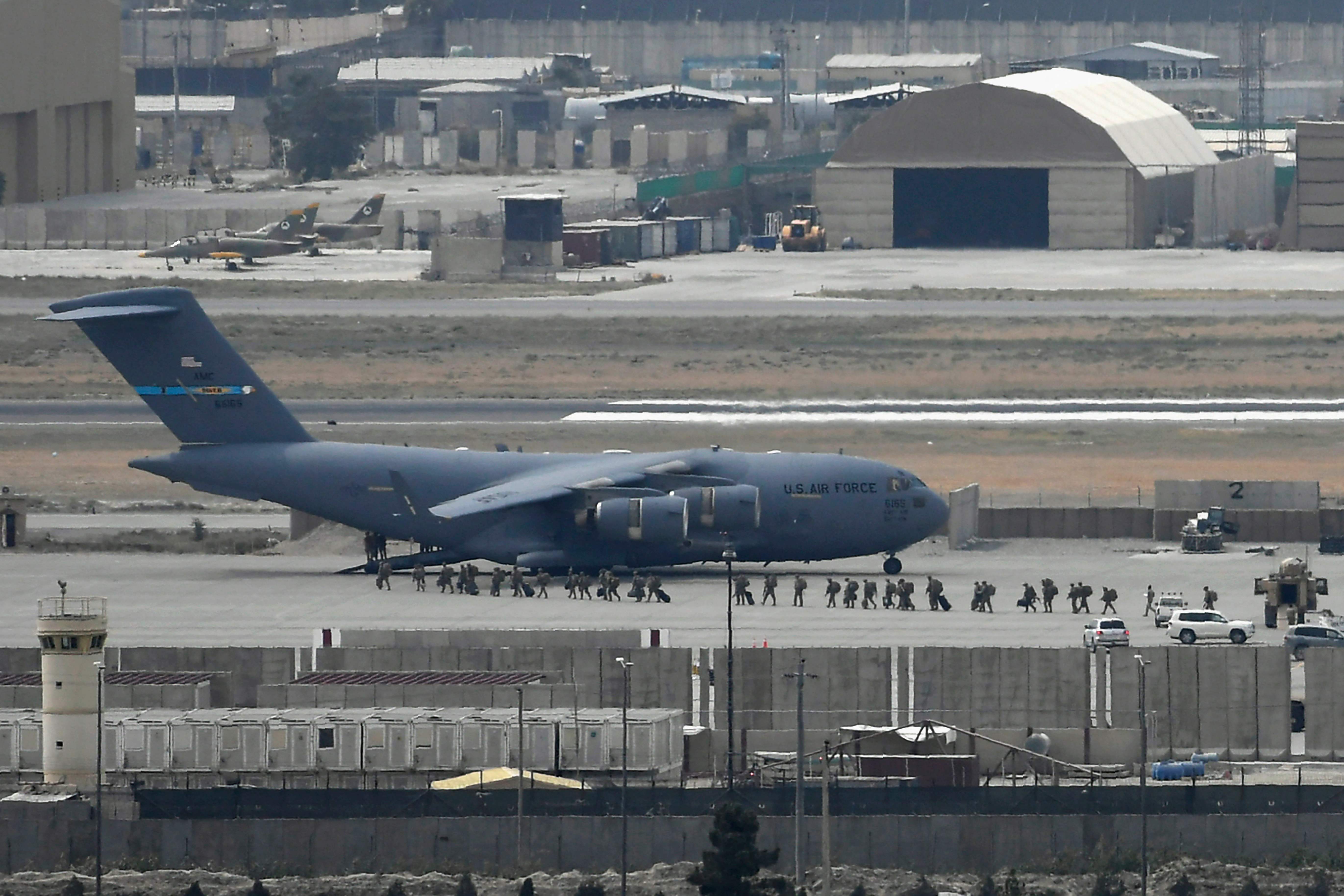 US soldiers board an US Air Force aircraft at the airport in Kabul on August 30, 2021. - Rockets were fired at Kabul's airport on August 30 where US troops were racing to complete their withdrawal from Afghanistan and evacuate allies under the threat of Islamic State group attacks. (Photo by Aamir QURESHI / AFP)
