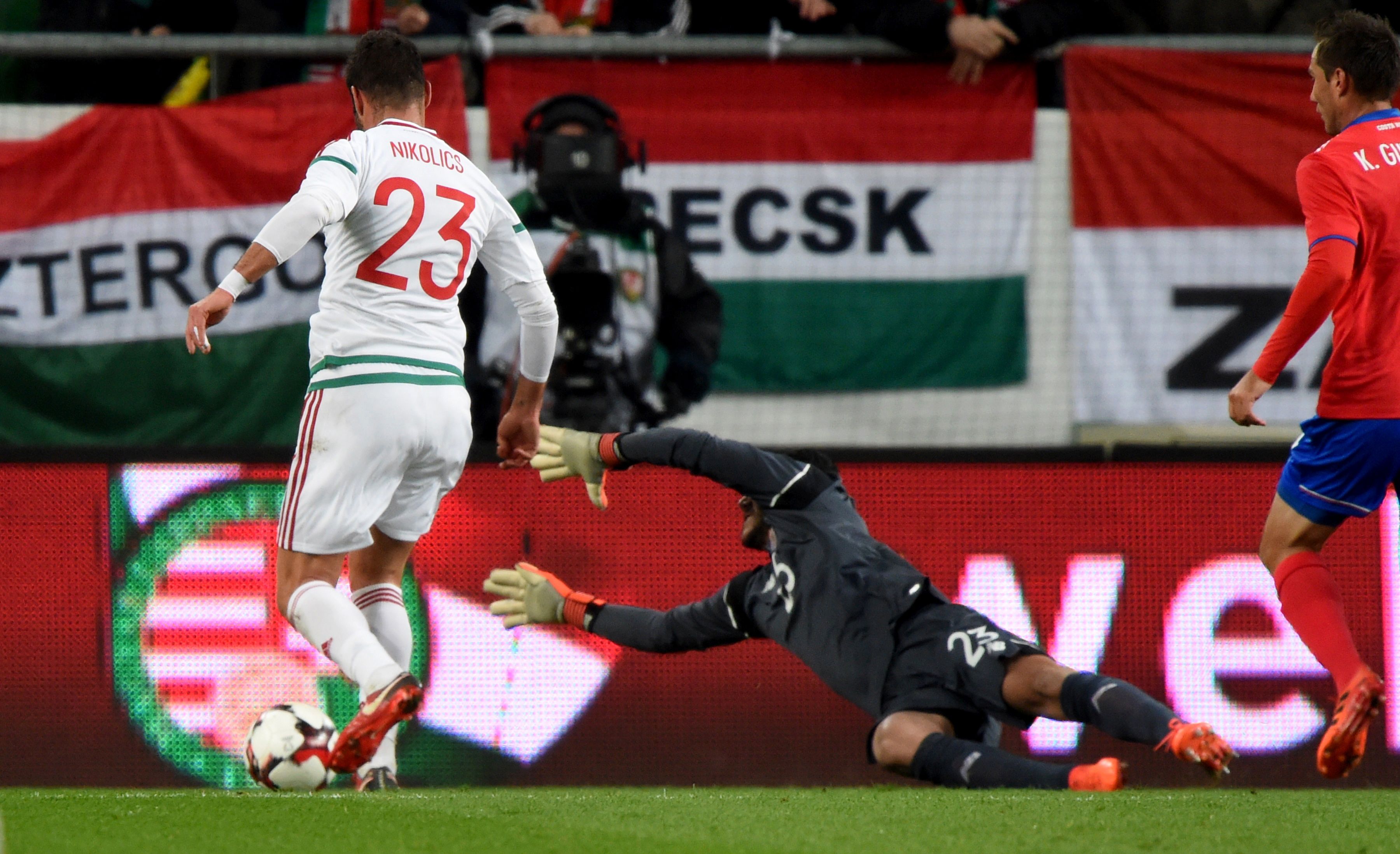 Costa Rica's goalkeeper Leonel Moreira (C) dives in front of Hungary's Nemanja Nikolic (L) during the international friendly football match Hungary against Costa Rica in Budapest on November 14, 2017. / AFP PHOTO / ATTILA KISBENEDEK