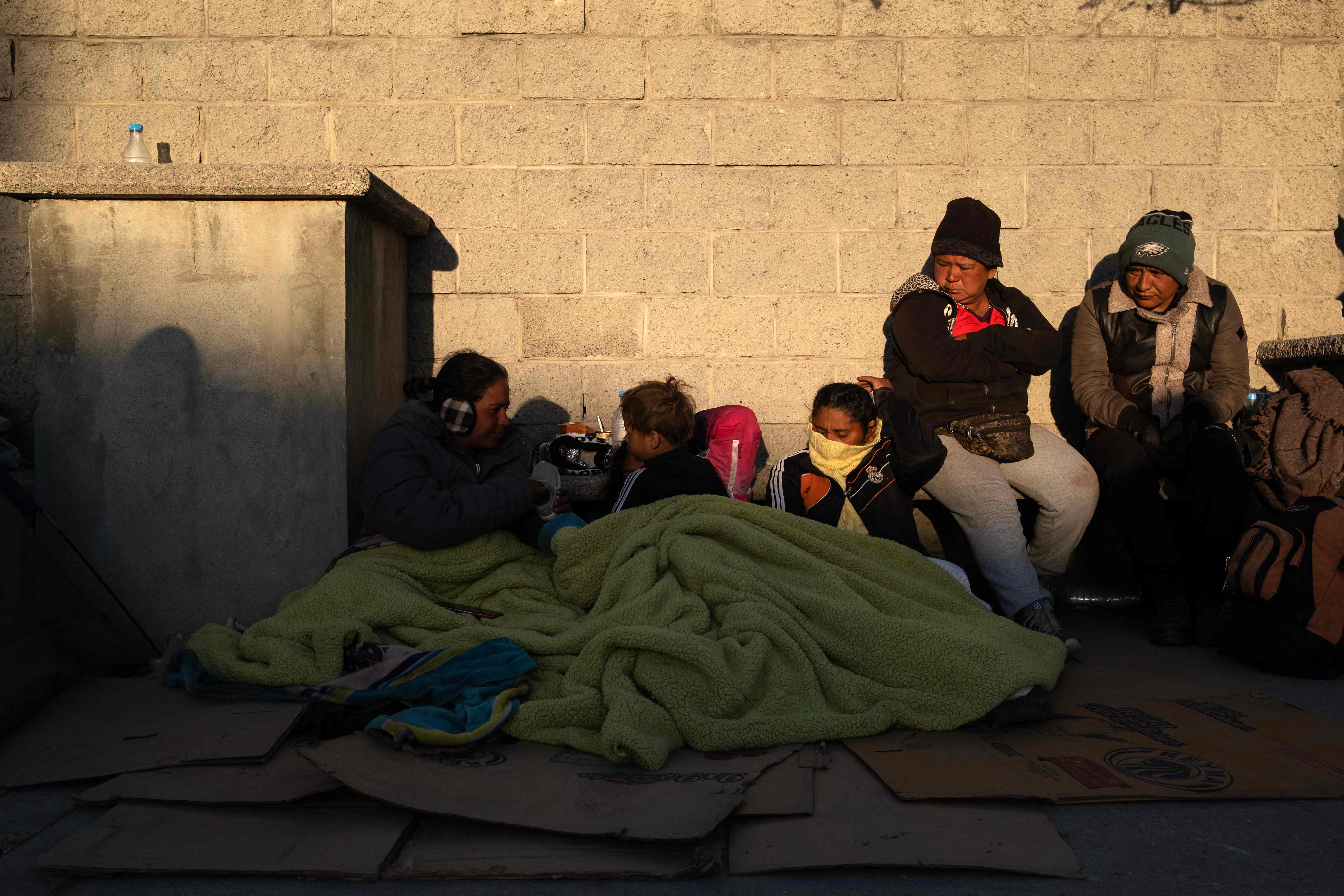Migrants wake up after spending the night outside the immigration detention center where 38 migrants died during a fire in Ciudad Juarez, Chihuahua state, Mexico on March 29, 2023. - Mexico's president vowed Wednesday there would be "no impunity" for those found responsible for the death by fire of 38 migrants at a detention center. "We will not hide anything and there will be no impunity," Andres Manuel Lopez Obrador said at his daily press briefing after the disaster at a detention center near the border late Monday. (Photo by Guillermo Arias / AFP)