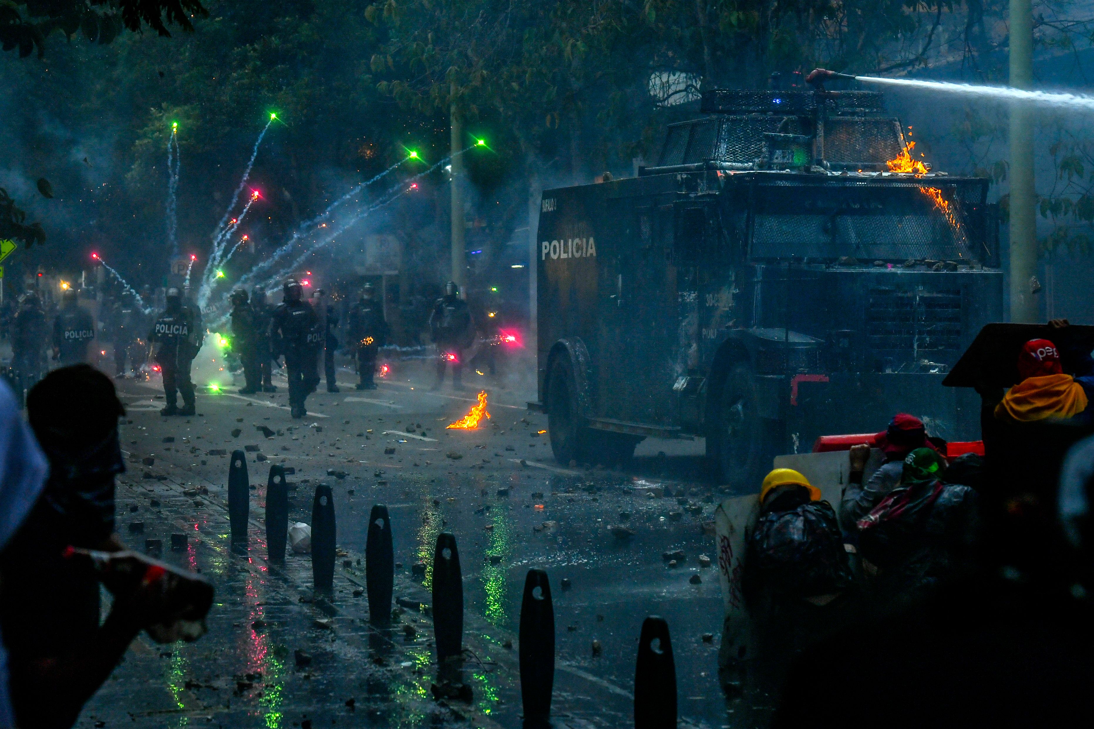 TOPSHOT - Demonstrators clash with riot police during a new protest against the government in Medellin, Colombia, on May 28, 2021. - Three people died Friday during anti-government protests in the Colombian city of Cali, authorities said, as the country marked a full month of social unrest that has claimed dozens of lives. (Photo by JOAQUIN SARMIENTO / AFP)