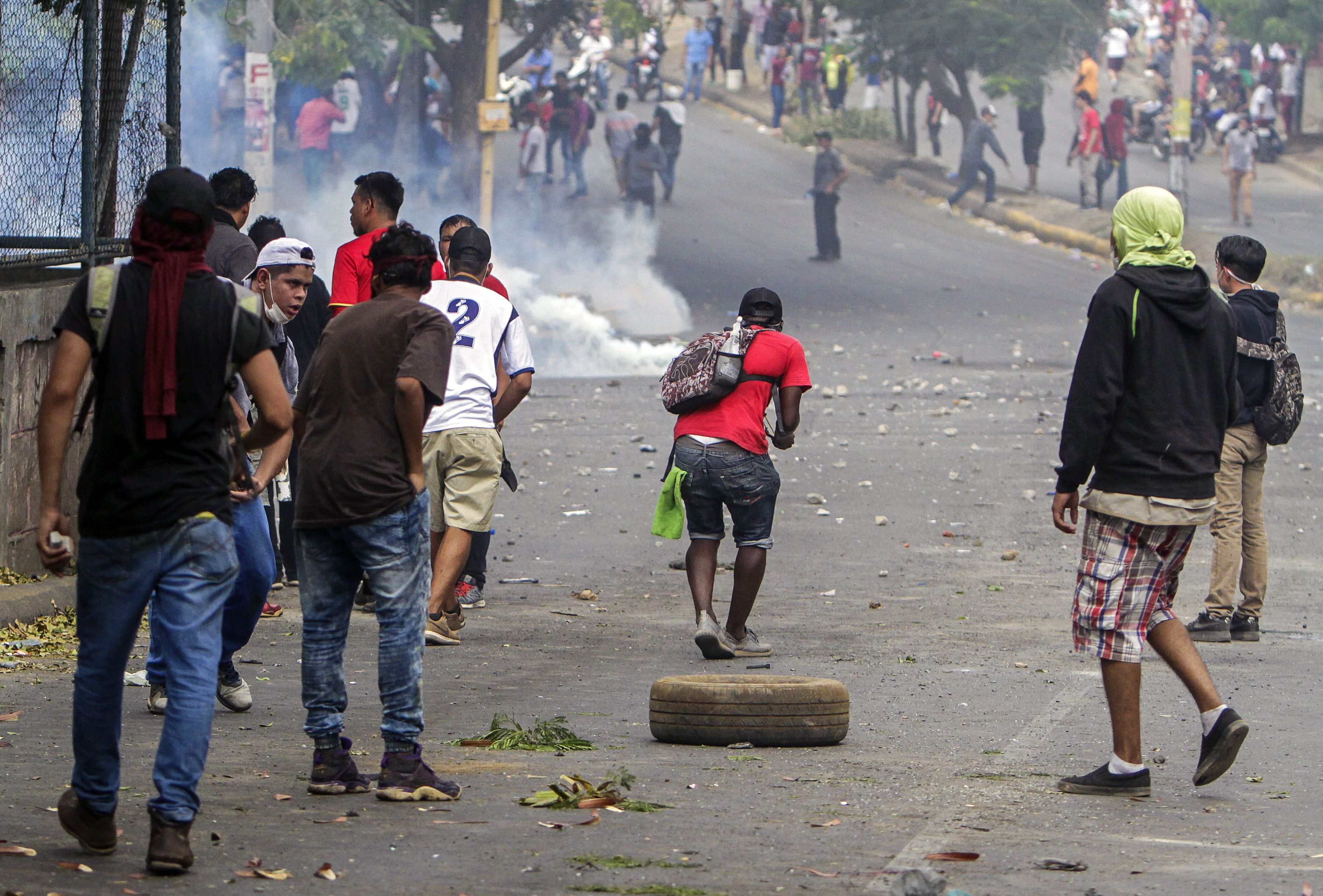 Students clash with riot police agents close to Nicaragua's Technical College during a protest against government's reforms in the Institute of Social Security (INSS) in Managua on April 21, 2018.
A protester and a policeman were killed in the Nicaraguan capital Managua after demonstrations over pension reform turned violent Thursday night, officials said. The deaths came after protests by both opponents and supporters of a new law, which increases employer and employee contributions while reducing the overall amount of pensions by five percent, rocked the capital for a second day. / AFP PHOTO / INTI OCON