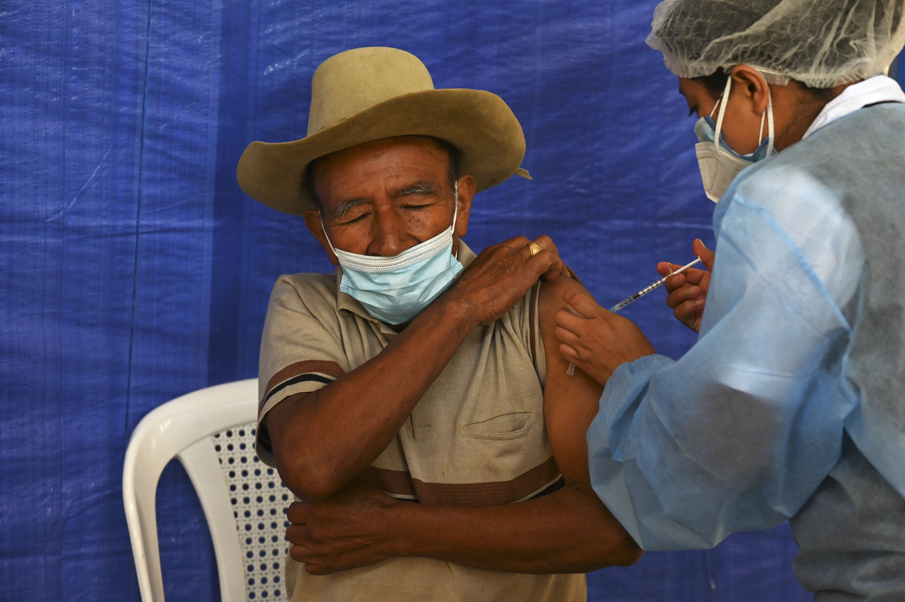 A man receives a dose of the AstraZeneca vaccine against COVID-19, donated by the US, at a vaccination center in San Juan Sacatepequez, Guatemala, on July 15, 2021. (Photo by Johan ORDONEZ / AFP)