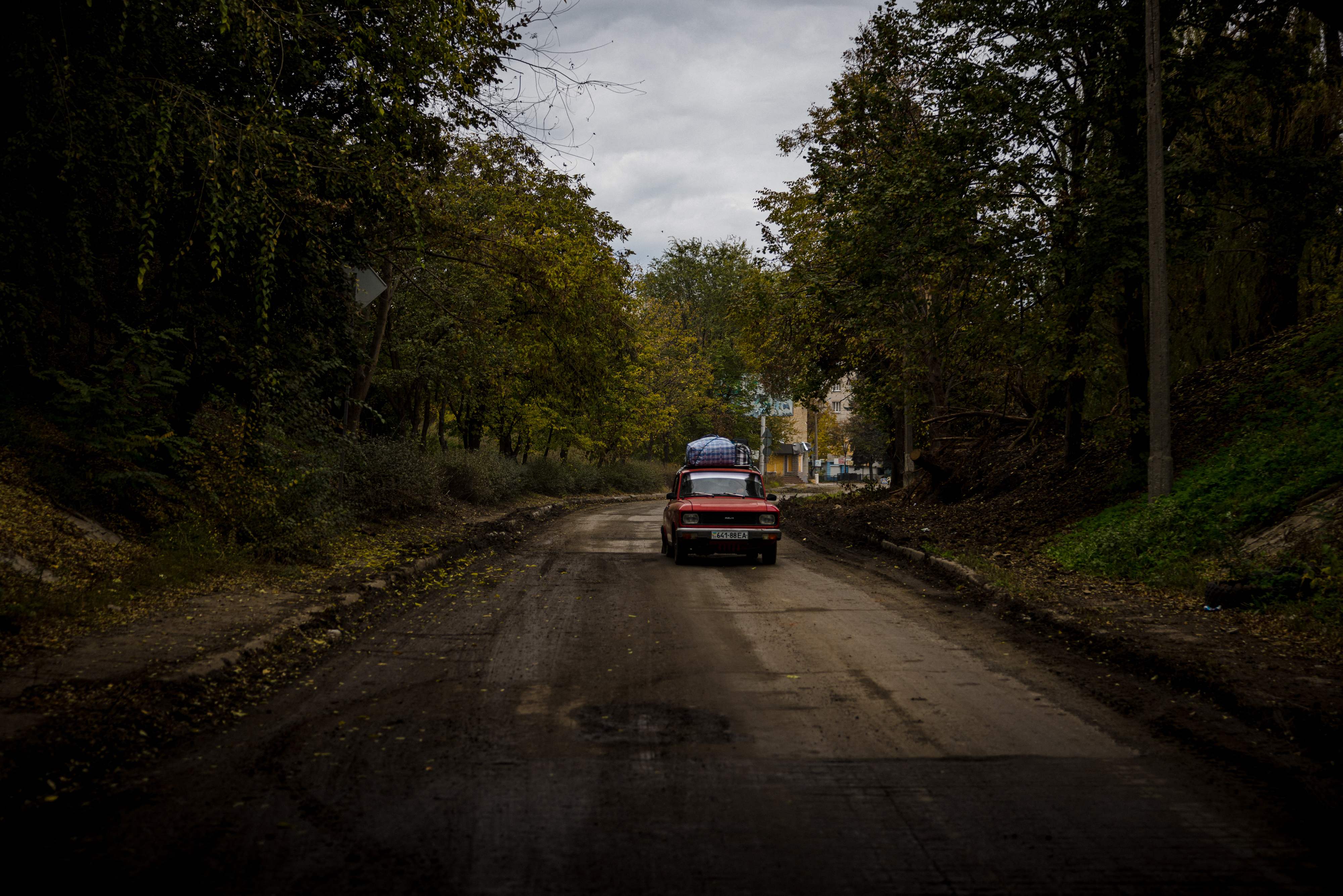 Local residents ride a Soviet-era Moskvitch car while leaving the town of Bakhmut, in eastern Ukraine's Donbas region, on October 23, 2022, amid the Russia invasion of Ukraine. (Photo by Dimitar DILKOFF / AFP)