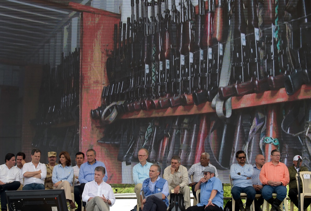 Altos funcionarios del Gobierno, entre ellos el presidente Juan Manuel Santos (izquierda, primera fila), y Rodrigo Londoño (con boina), líder de las FARC, asistieron el martes a la ceremonia oficial de desarme de la guerrilla.