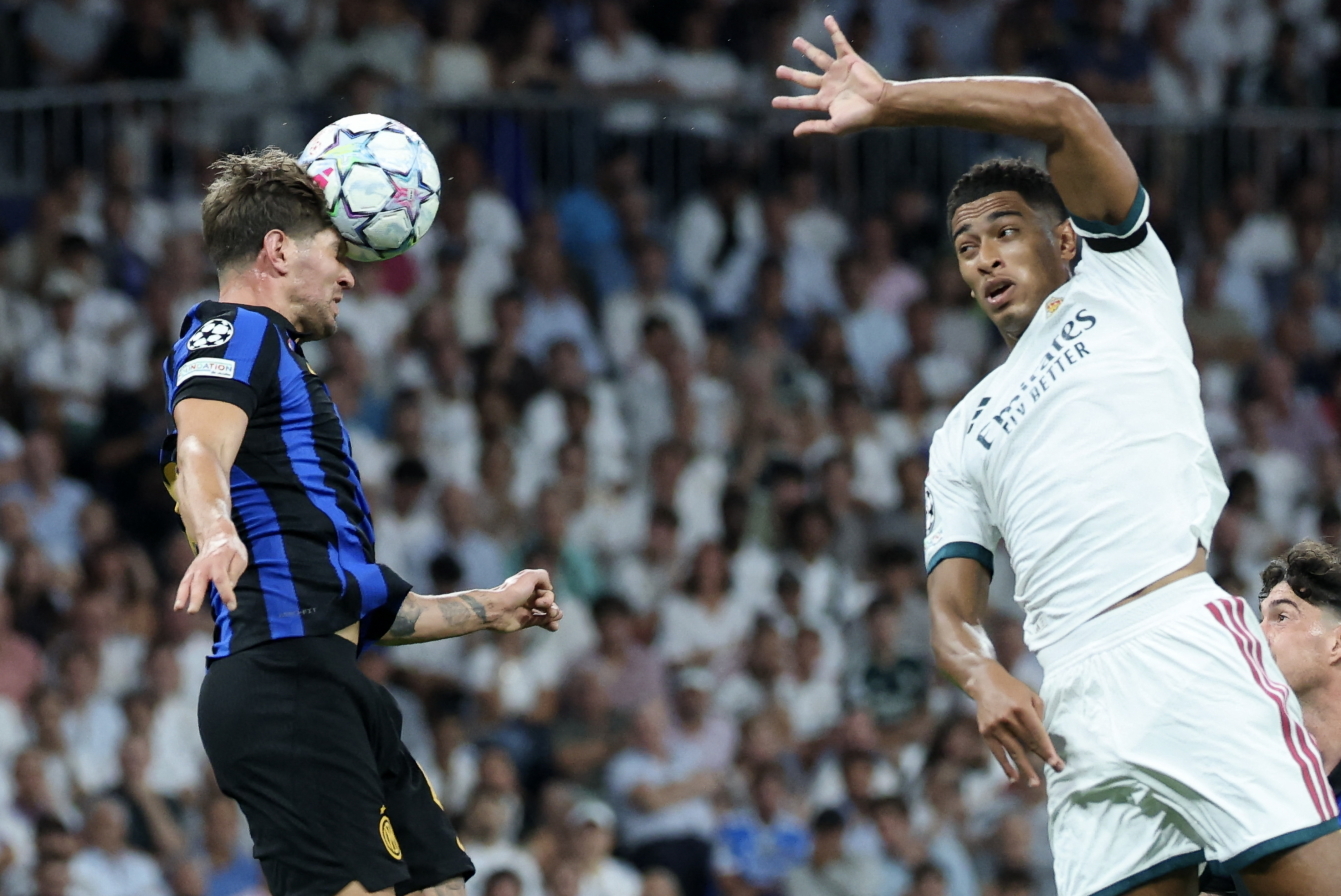 El defensor inglés del Inter de Milán, John Stones, cabecea ante la marca de su compatriota del Real Madrid, Jude Bellingham, en el estadio Santiago Bernabéu durante el inicio de la nueva Champions League.