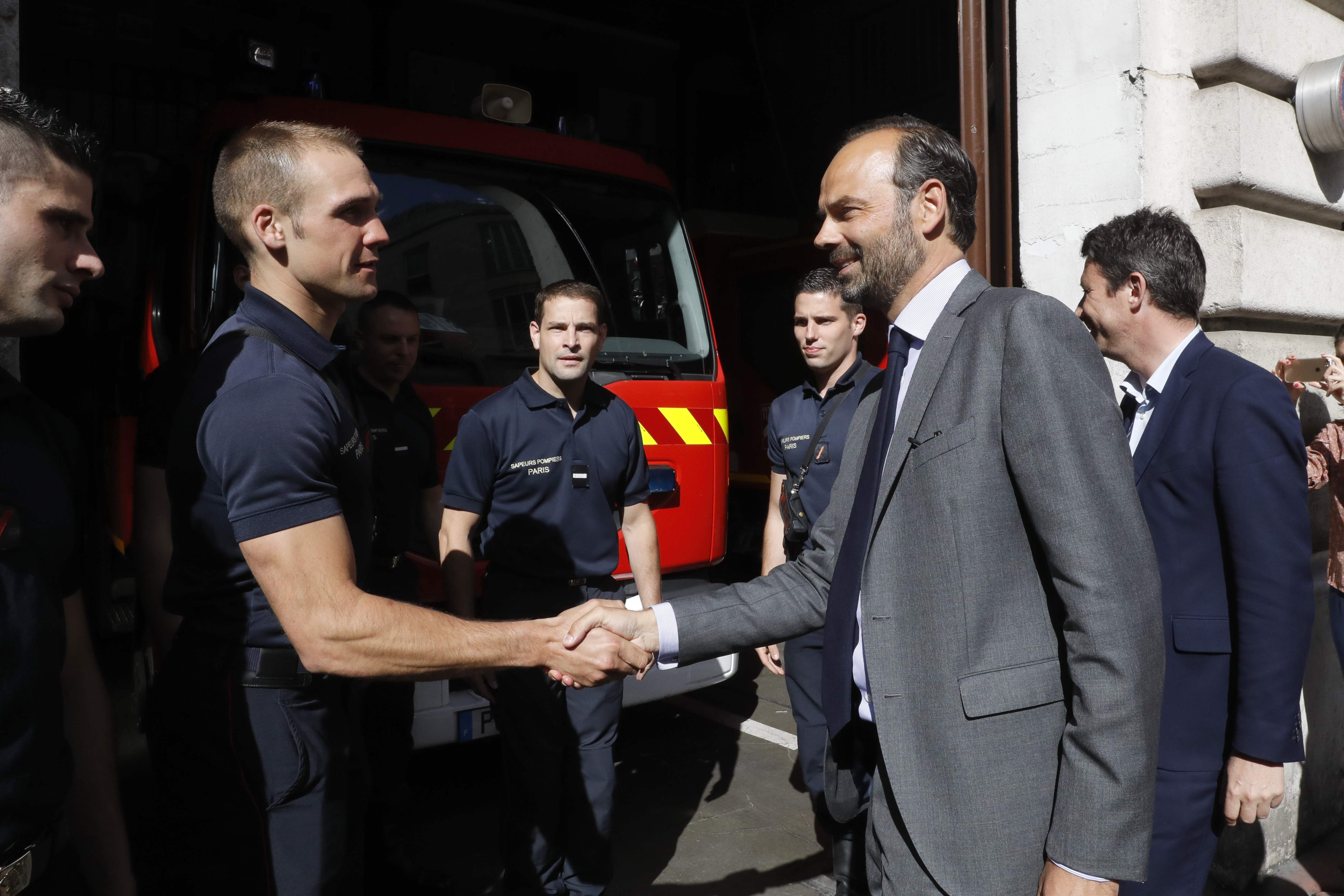 El primer ministro francés Edouard Philippe estrecha la mano de un bombero mientras hace campaña en apoyo del candidato del partido de la República en Marche (REM),Benjamin Griveaux, en París.