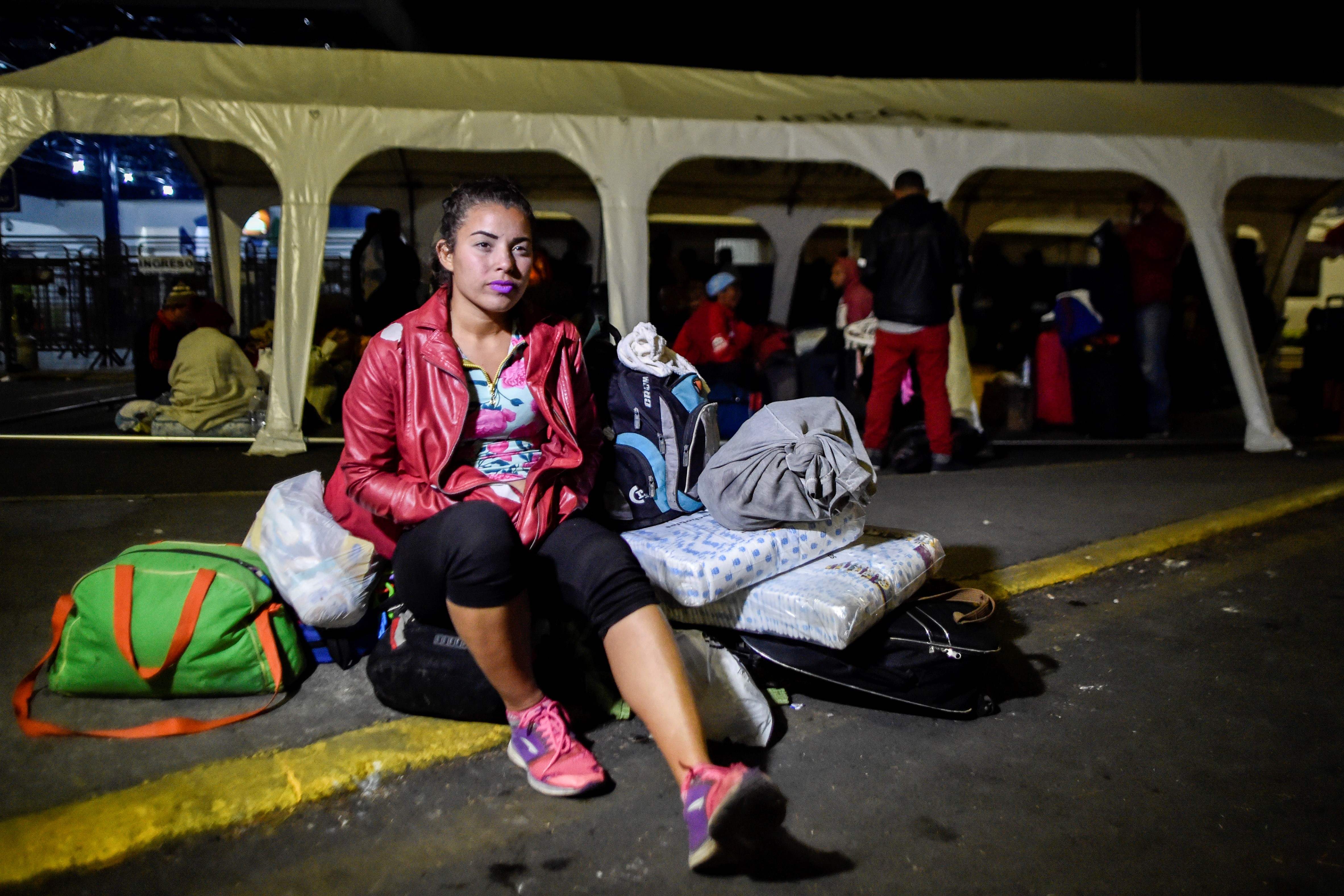 Venezuelan migrant Mariangela Ascano, 21, remains outside the Ecuadorean migrations office at the Rumichaca International Bridge, in the border between Ipiales, Colombia, and Tulcan, Ecuador, on August 23, 2018. - Mariangela Ascano, mother of a two-year-old boy and with a pregnancy of two months, left Marcay 20 day ago with the goal of reaching Quito. (Photo by Luis ROBAYO / AFP)