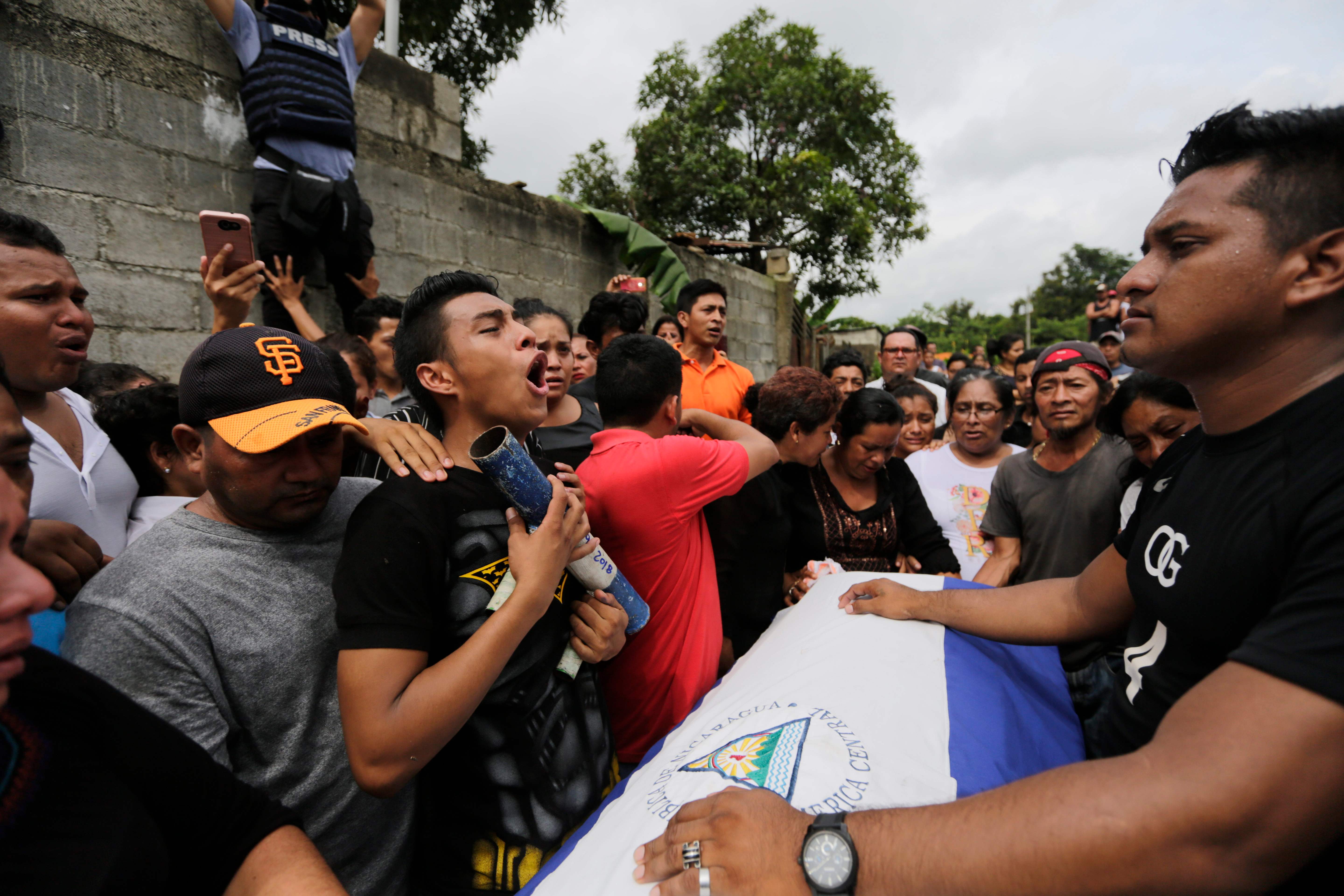 A relative of Marvin Lopez, 49, who was shot in the throat during clashes with riot police and members of the Sandinista youth, holds a home-made mortar as he yells the national anthem during the funeral in Masaya, about 35 km from Managua on June 20, 2018.
Residents in the Nicaraguan opposition bastion of Masaya were on Wednesday holding off an offensive by police and pro-government paramilitaries as fresh violence flared across the Central American country. Funerals were held for three people killed in clashes in the flashpoint city on Tuesday, bringing to 187 the number of dead since protests against President Daniel Ortega's government began on April 18.
/ AFP PHOTO / Inti OCON