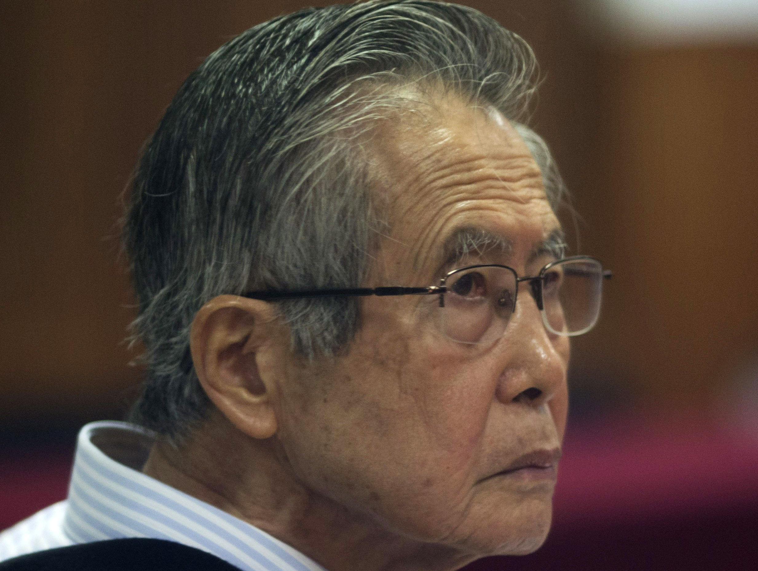 FILE - In this June 28, 2016 file photo, Peru's jailed, former President Alberto Fujimori, photographed through a glass window, attends his trial at a police base on the outskirts of Lima, Peru. Fujimori, has been moved to a private hospital, Tuesday, August 29 2017, after suffering from cardiac troubles. (AP Photo/Martin Mejia, File)