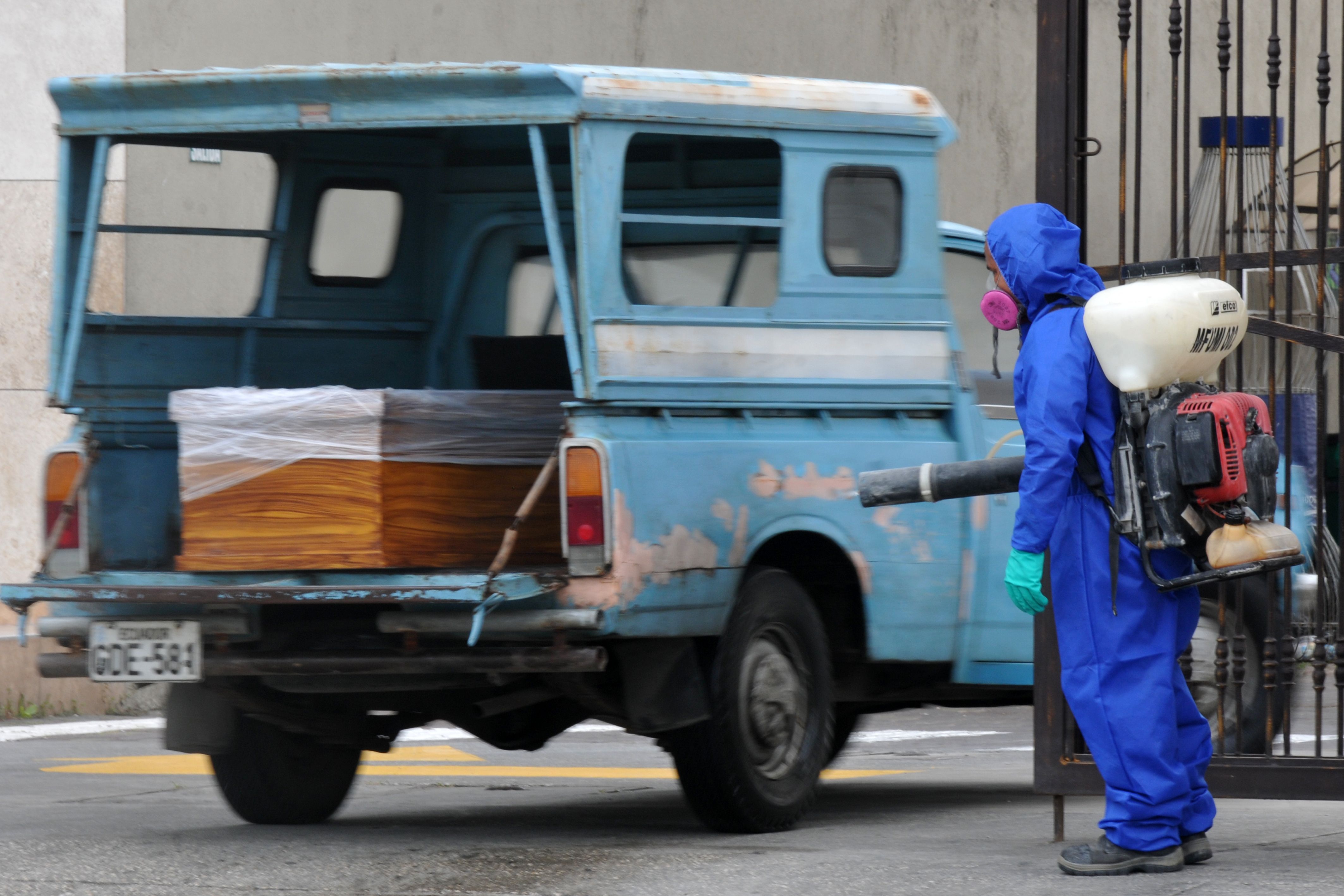 A coffin containing the corpse of a victim of the novel coronavirus COVID-19 is brought to the Jardines de la Esperanza cemetery in northern Guayaquil, Ecuador, on April 9, 2020. - In the badly affected city of Guayaquil in Ecuador, sick patients are passing out before arriving at emergency care and the elderly are slumped outside in wheelchairs. (Photo by Jose SANCHEZ / AFP)
