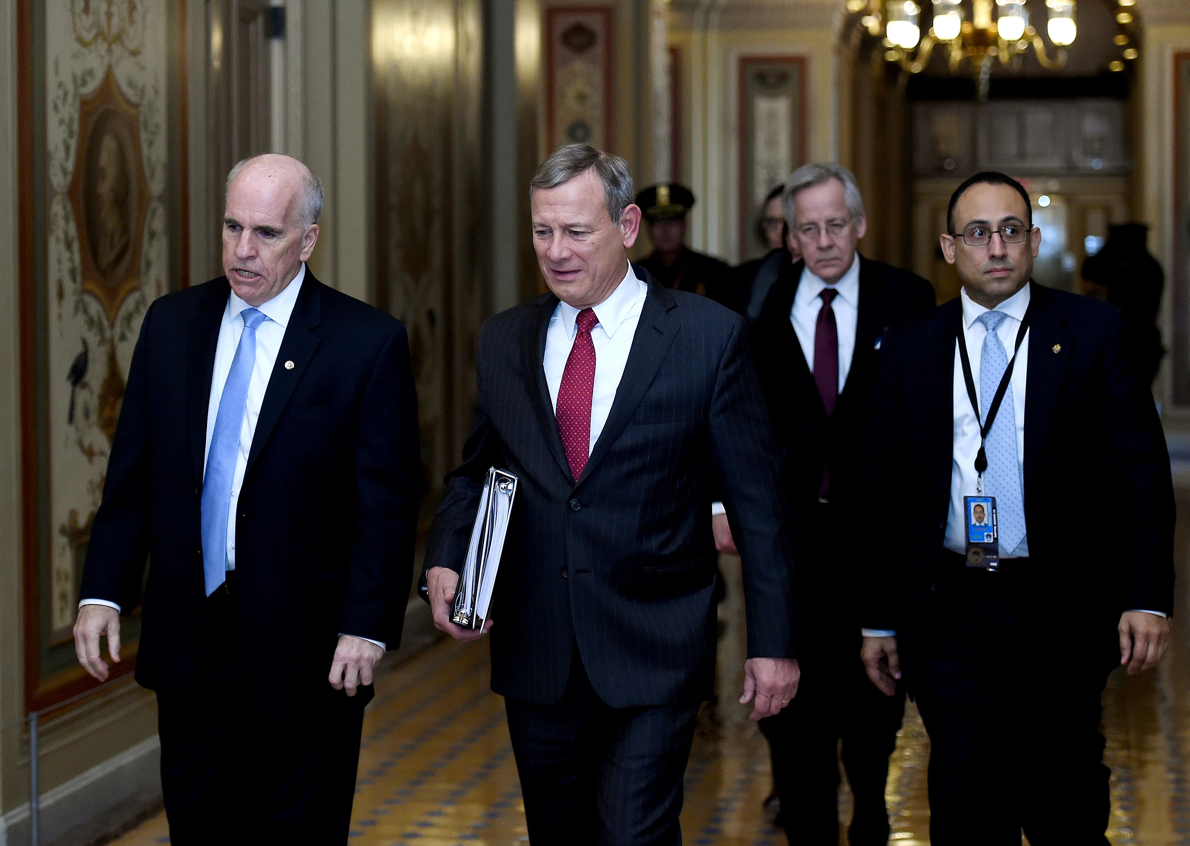 US Supreme Court Chief Justice John Roberts (C) leaves the US Capitol, January 16, 2020, in Washington, DC. - With the Senate formally accepting the two articles of impeachment, Chief Justice Roberts was sworn in Thursday to preside over the impeachment trial of US President Donald Trump. Roberts then swore in the 100 senators, who together will serve as a court of impeachment. (Photo by OLIVIER DOULIERY / AFP)
