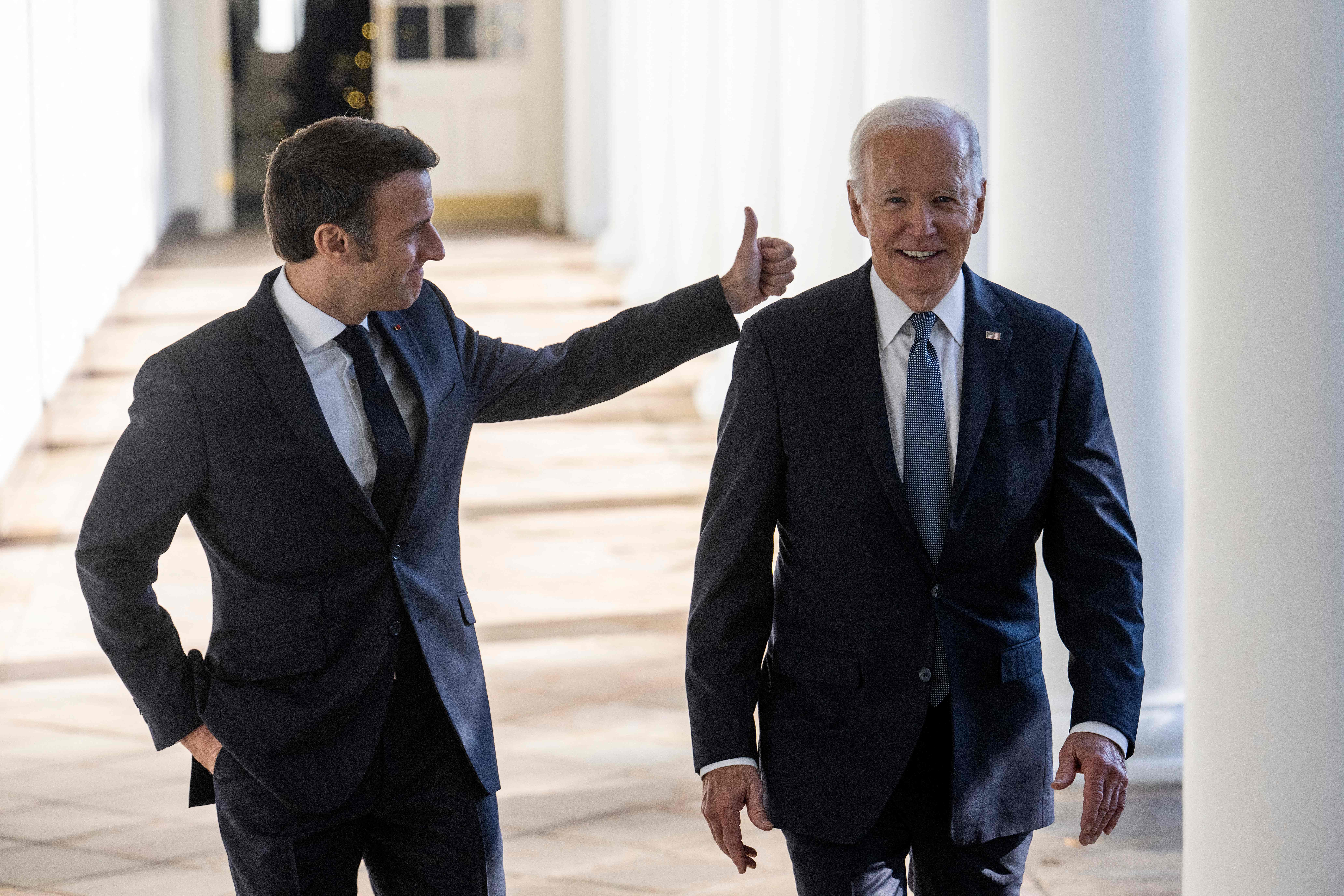 TOPSHOT - US President Joe Biden and French President Emmanuel Macron walk down the Colonnade at the White House in Washington, DC, on December 1, 2022. (Photo by Jim WATSON / AFP)