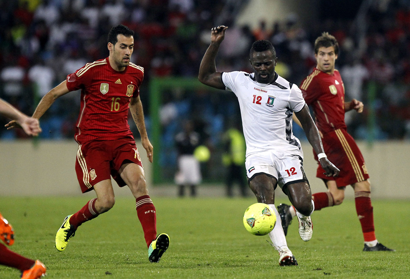 El español Sergio Busquets (16) llega a la marca de Thierry Fidjeu, de Guinea Ecuatorial. Los campeones del mundo ganaron 1-2, en Malabo. | AFP
