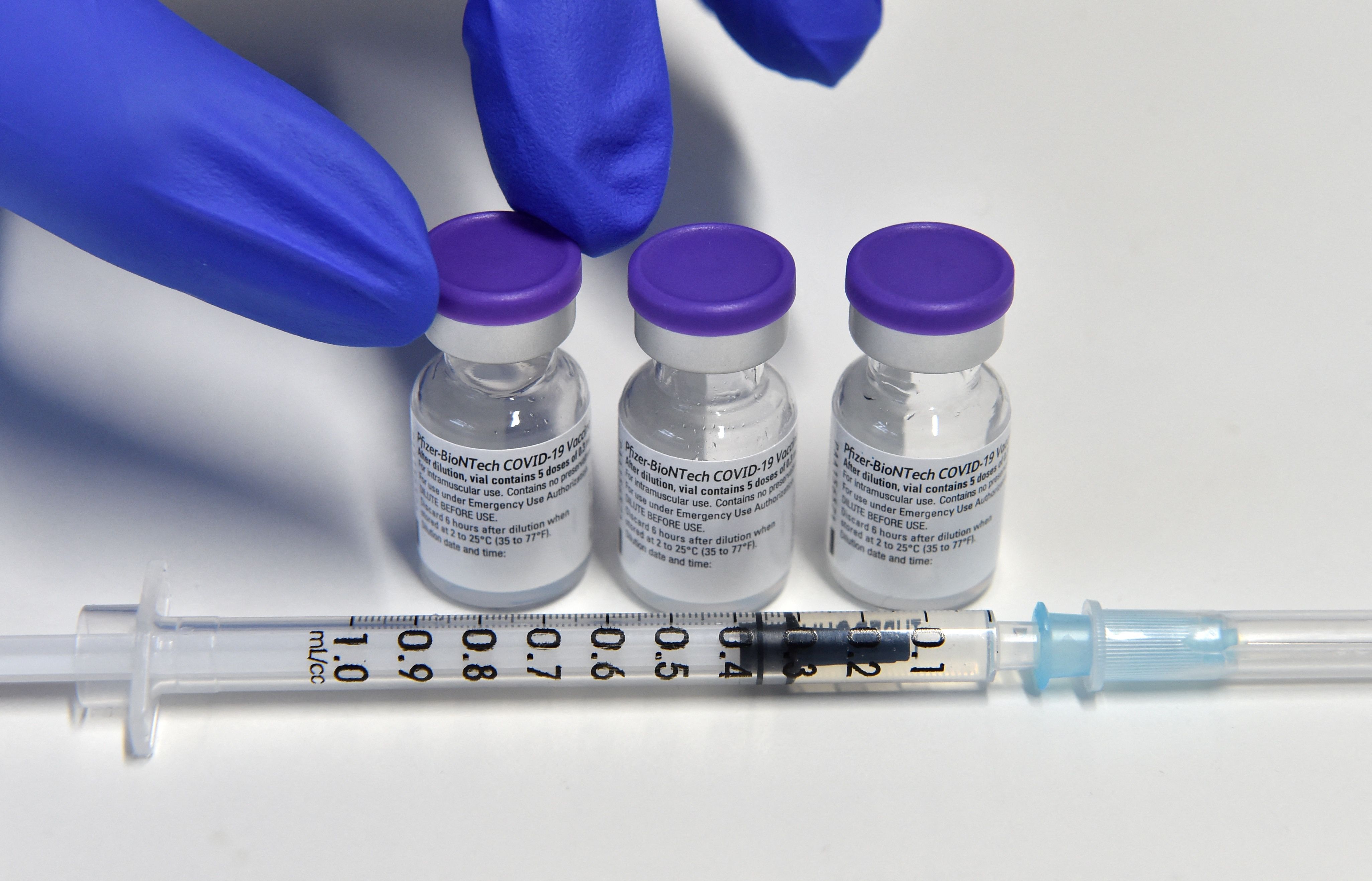 (FILES) In this file photo taken on February 02, 2021 a health worker holds a vial with the Pfizer-BioNTech COVID-19 vaccine against the coronavirus at the vaccination center in Freising, southern Germany. - A booster shot of the anti-Covid-19 vaccine developed by Pfizer/BioNTech is 95.6 percent effective against symptomatic infection, according to trial data published by the makers on October 21, 2021. The clinical phase three trial with "10,000 participants 16 years of age and older" showed "a relative vaccine efficacy of 95.6 percent against disease during a period when Delta was the prevalent strain", the companies said in a statement. (Photo by Christof STACHE / AFP)