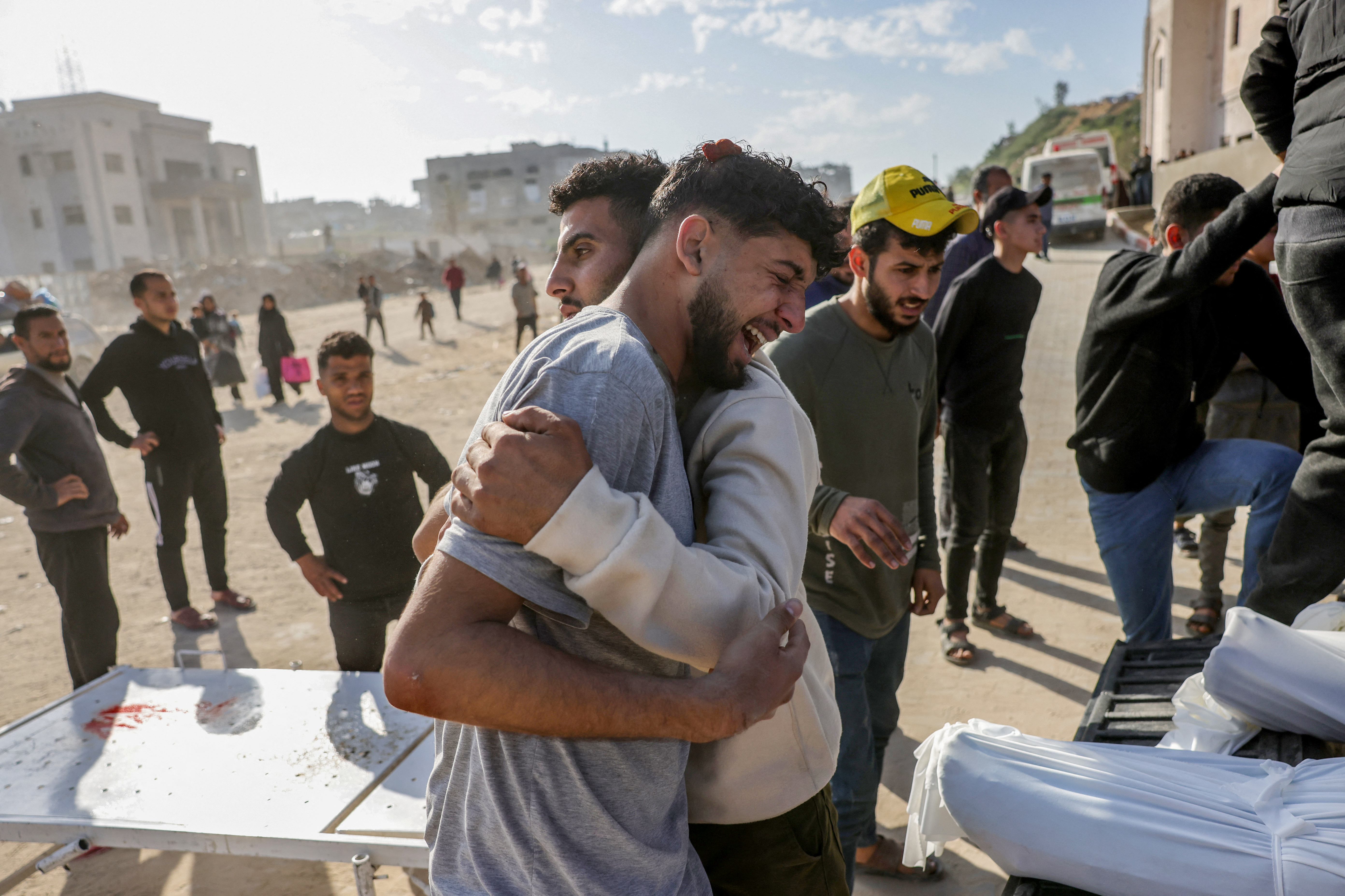 A Palestinian man is comforted as he weeps next to a truck carrying the bodies of the victims of Israeli overnight airstrikes before transporting them from the Indonesian Hospital in Beit Lahia in northern Gaza for burial on March 18, 2025. Israel on March 18 unleashed its most intense strikes on the Gaza Strip since a January ceasefire, with rescuers reporting 220 people killed, and Hamas accusing Benjamin Netanyahu of deciding to "resume war" after a deadlock on extending the truce. (Photo by BASHAR TALEB / AFP)
