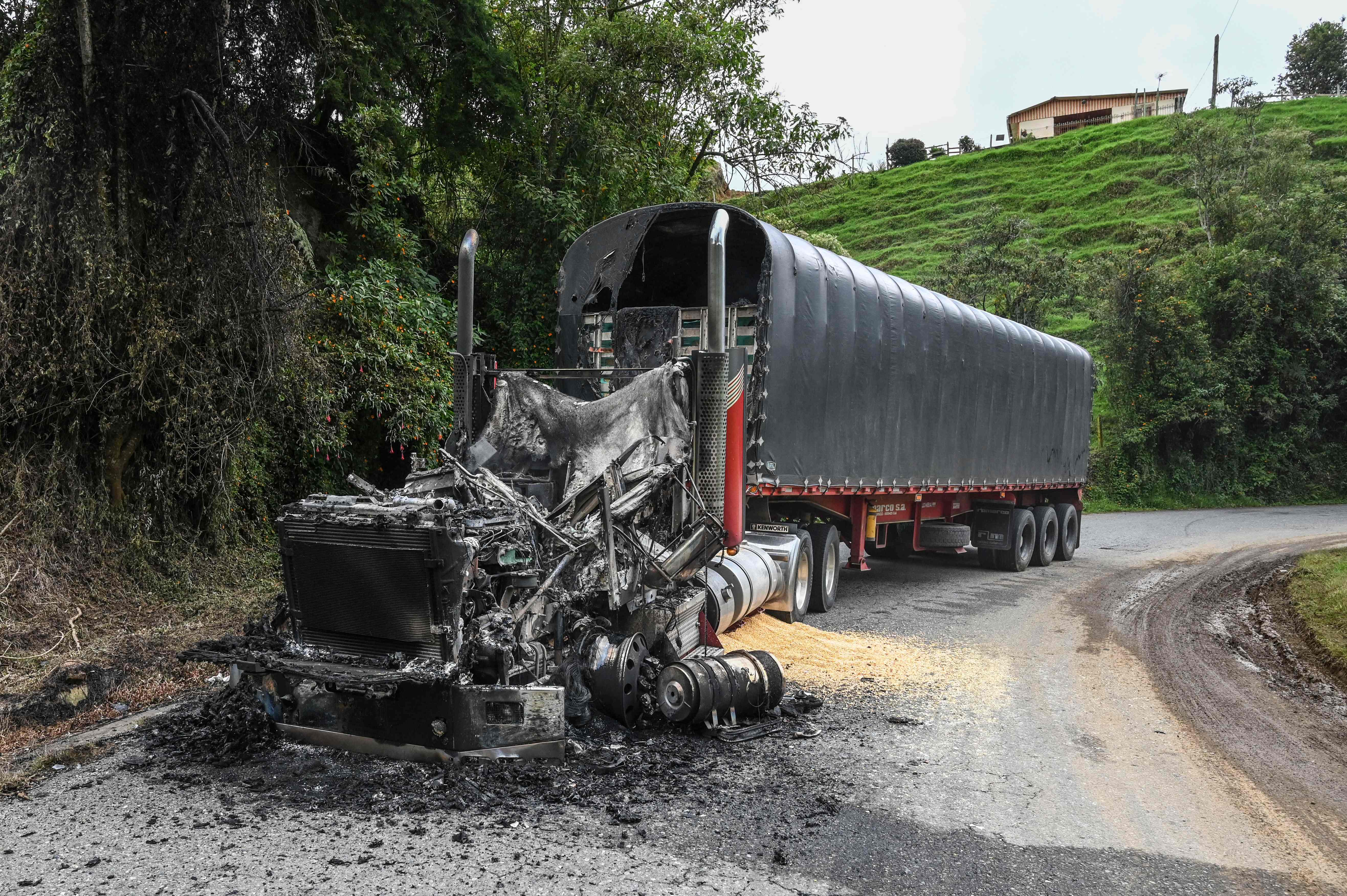 TOPSHOT - View of a truck burnt by members of the Clan del Golfo drug cartel near San Pedro de los Milagros, Antioquia department, Colombia, on May 6, 2022. - The criminal gang Clan del Golfo announced a five-day armed strike in retaliation for the extradition to the United States of drug lord Dairo Antonio Usuga, alias 'Otoniel', who until a few months ago was the head of that organization. (Photo by JOAQUIN SARMIENTO / AFP)
