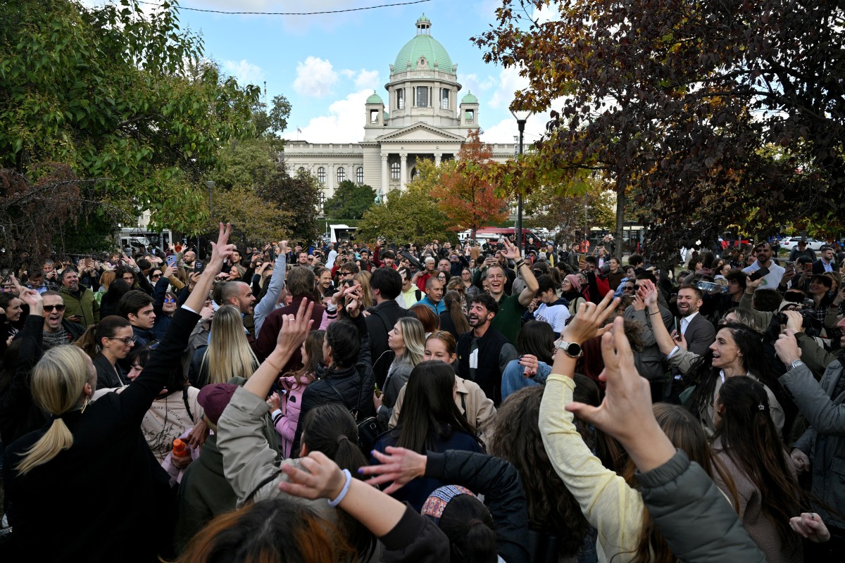 Simpatizantes del movimiento estudiantil bailan en un parque frente al Parlamento de Serbia, en Belgrado, el 26 de octubre de 2026.