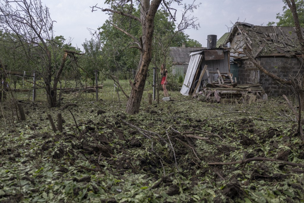 A woman looks on, near the site where a rocket landed earlier, in Kramatorsk, on August 11, 2022, amid the Russian invasion of Ukraine. (Photo by Bulent KILIC / AFP)
