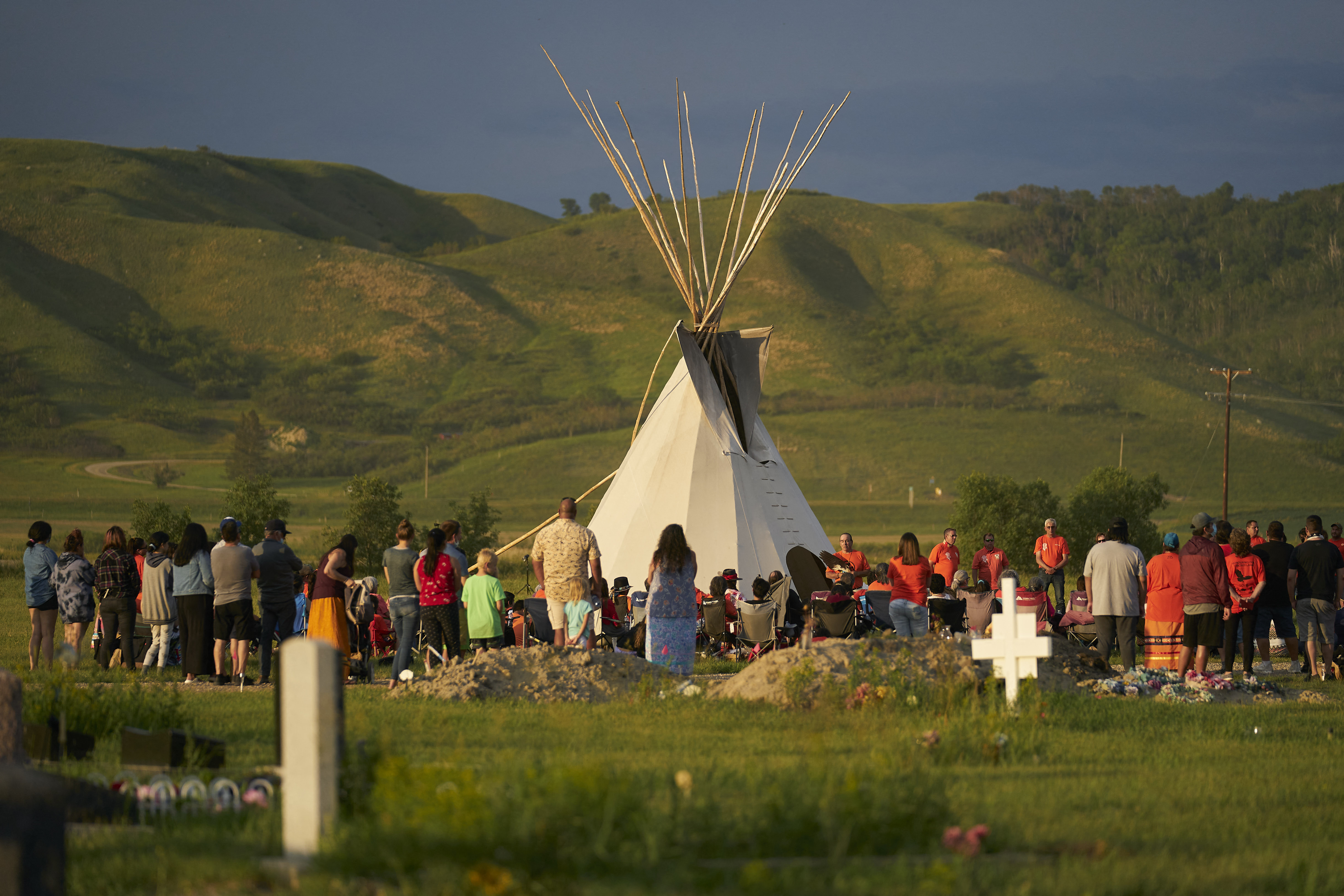 Hundreds of people gather for a vigil in a field where human remains were discovered in unmarked graves at the site of the former Marieval Indian Residential School on the Cowessess First Nation in Saskatchewan on June 26, 2021. - More than 750 unmarked graves have been found near a former Catholic boarding school for indigenous children in western Canada, a tribal leader said Thursday -- the second such shock discovery in less than a month. (Photo by Geoff Robins / AFP)