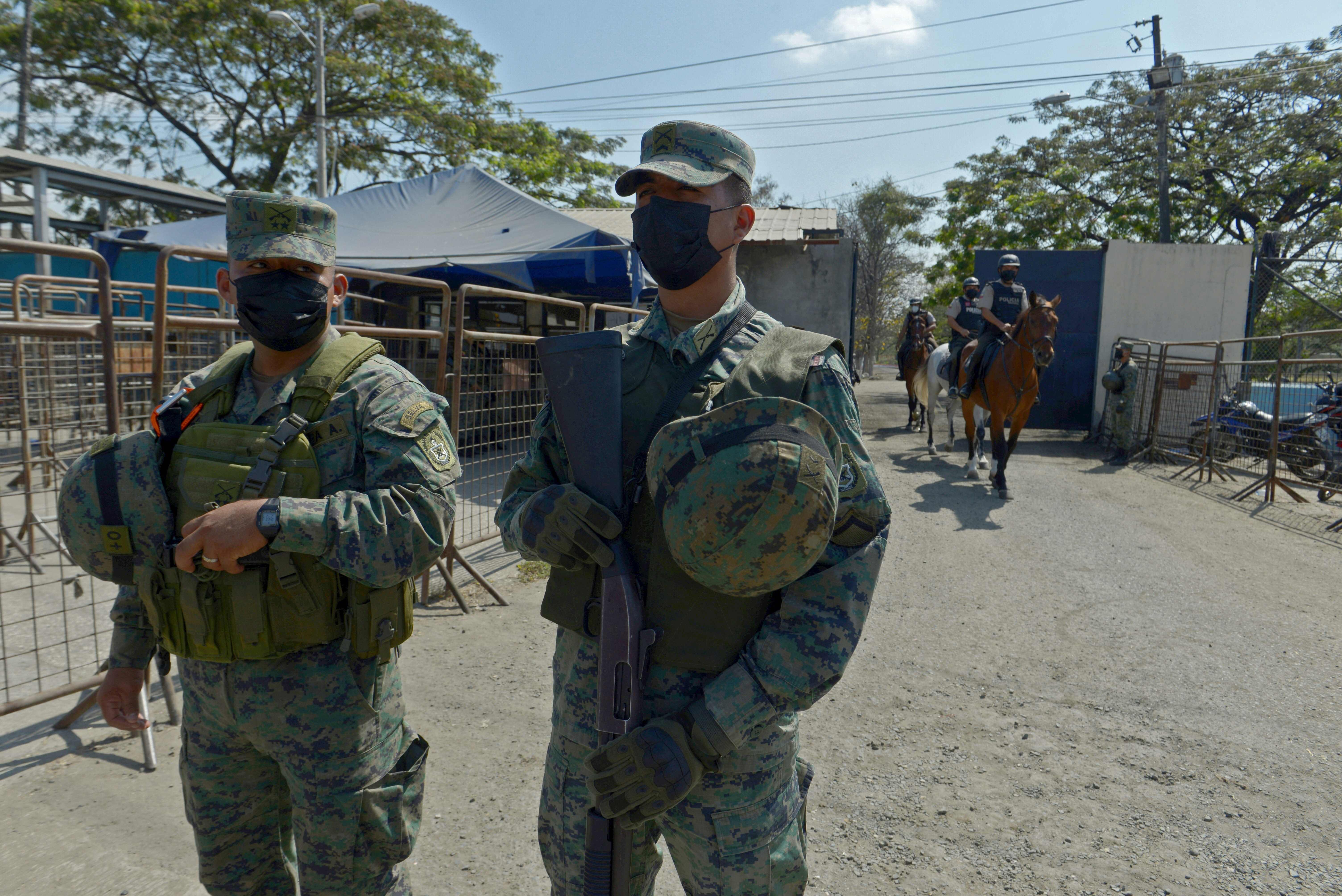 Soldiers stand guard outside a prison in Guayaquil, Ecuador on September 29, 2021, after a riot occurred. - Thirty prisoners were killed and 47 wounded in a battle between armed inmates aligned to rival gangs at a jail in Ecuador's largest city Tuesday, officials said. (Photo by Fernando MENDEZ / AFP)