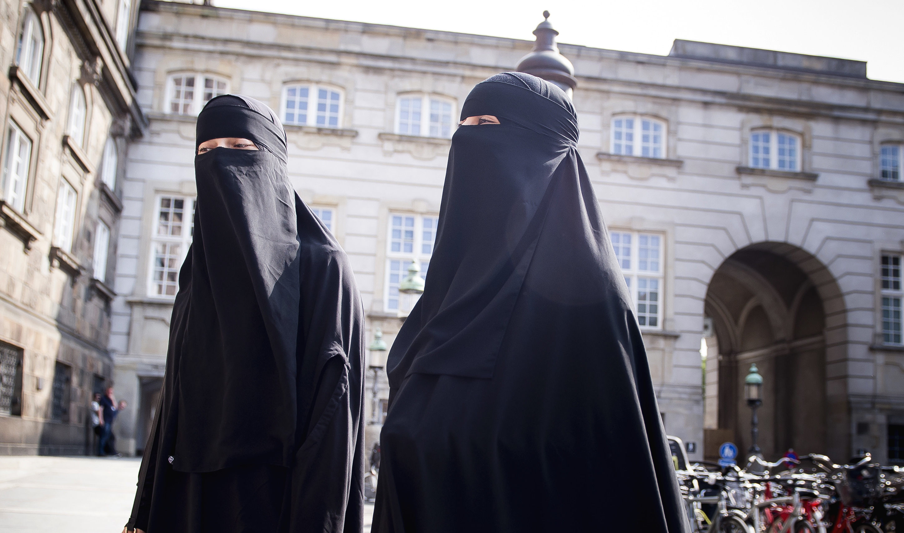 Mujeres caminan frente al Parlamento danés, en el castillo de Christiansborg, en Copenhague, Dinamarca, el jueves 31 de mayo de 2018, usando burka. Dinamarca se suma a otros países europeos para prohibir las prendas que cubren la cara, incluidos los velos islámicos como el niqab o burka. AP