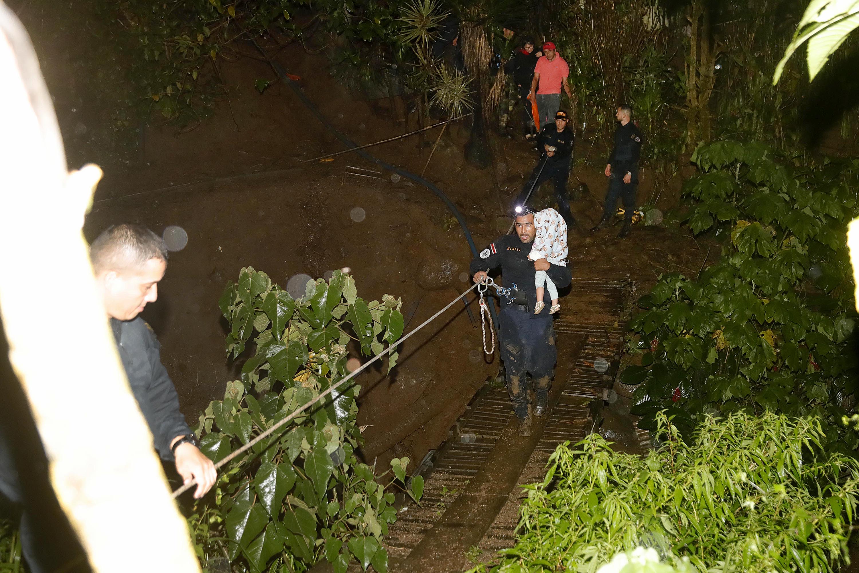 17/09/2022 Salitrillos de Aserrí. Miembros de la Fuerza Pública ayudaron a salir a alguas personas que quedaron aisladas en Calle Lajas debido a que la crecida del río Cañas arrazó con el puente, por las fuertes lluvias de esta tarde. Miembros de la Fuerza Pública le entregaron la bebé, Alana Cerdas Marín, de año y tres meses, a su madre Jiména Marín Quirós quien la esperaba del otro lado del río.