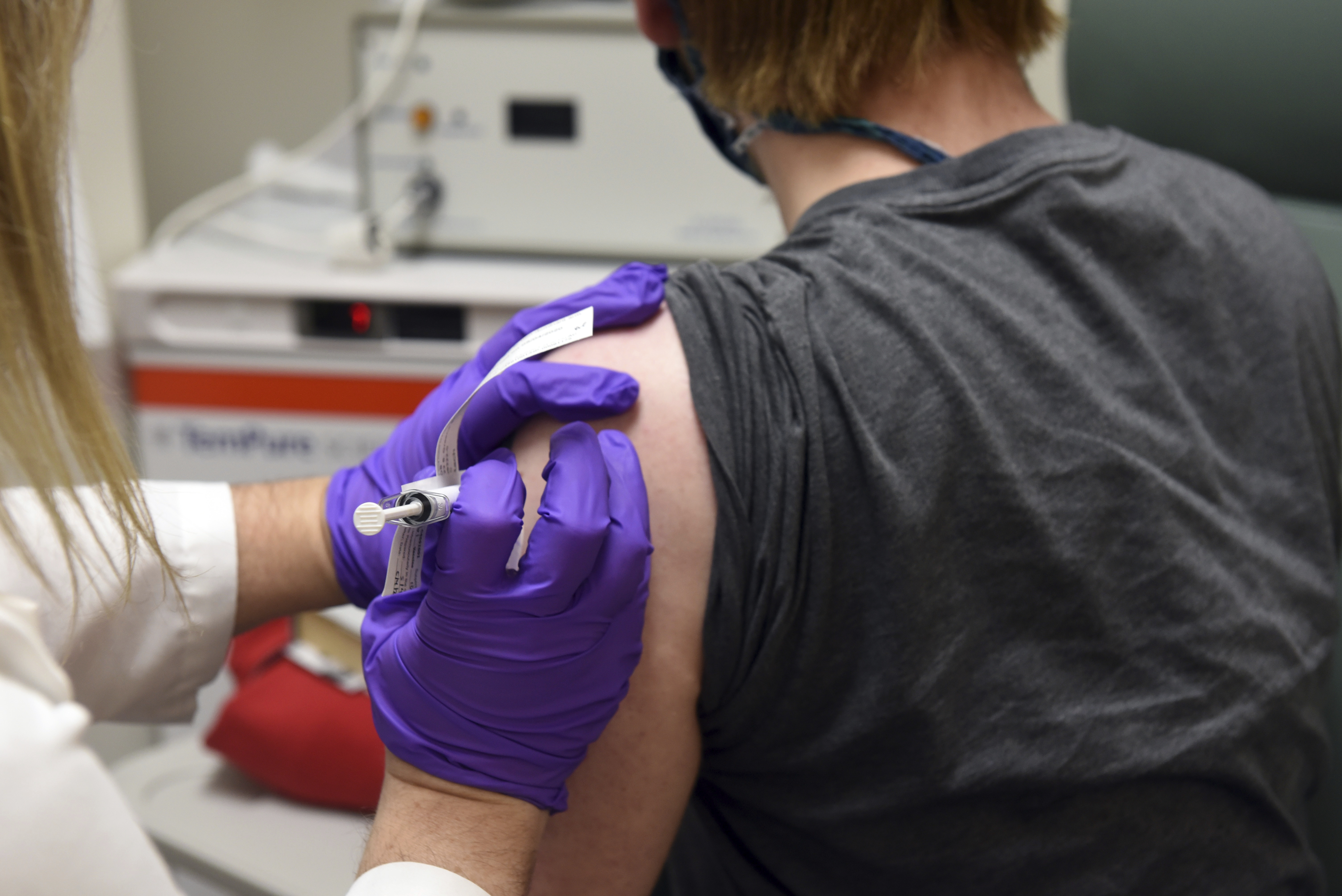 FILE - In this May 4, 2020 photo provided by the University of Maryland School of Medicine, the first patient enrolled in Pfizer's COVID-19 coronavirus vaccine clinical trial at the University of Maryland School of Medicine in Baltimore, receives an injection. The first of four experimental COVID-19 vaccines being tested by Pfizer and its German partner BioNTech showed encouraging results in very early testing of 45 people, the companies said Wednesday, July 1, 2020. (University of Maryland School of Medicine via AP)