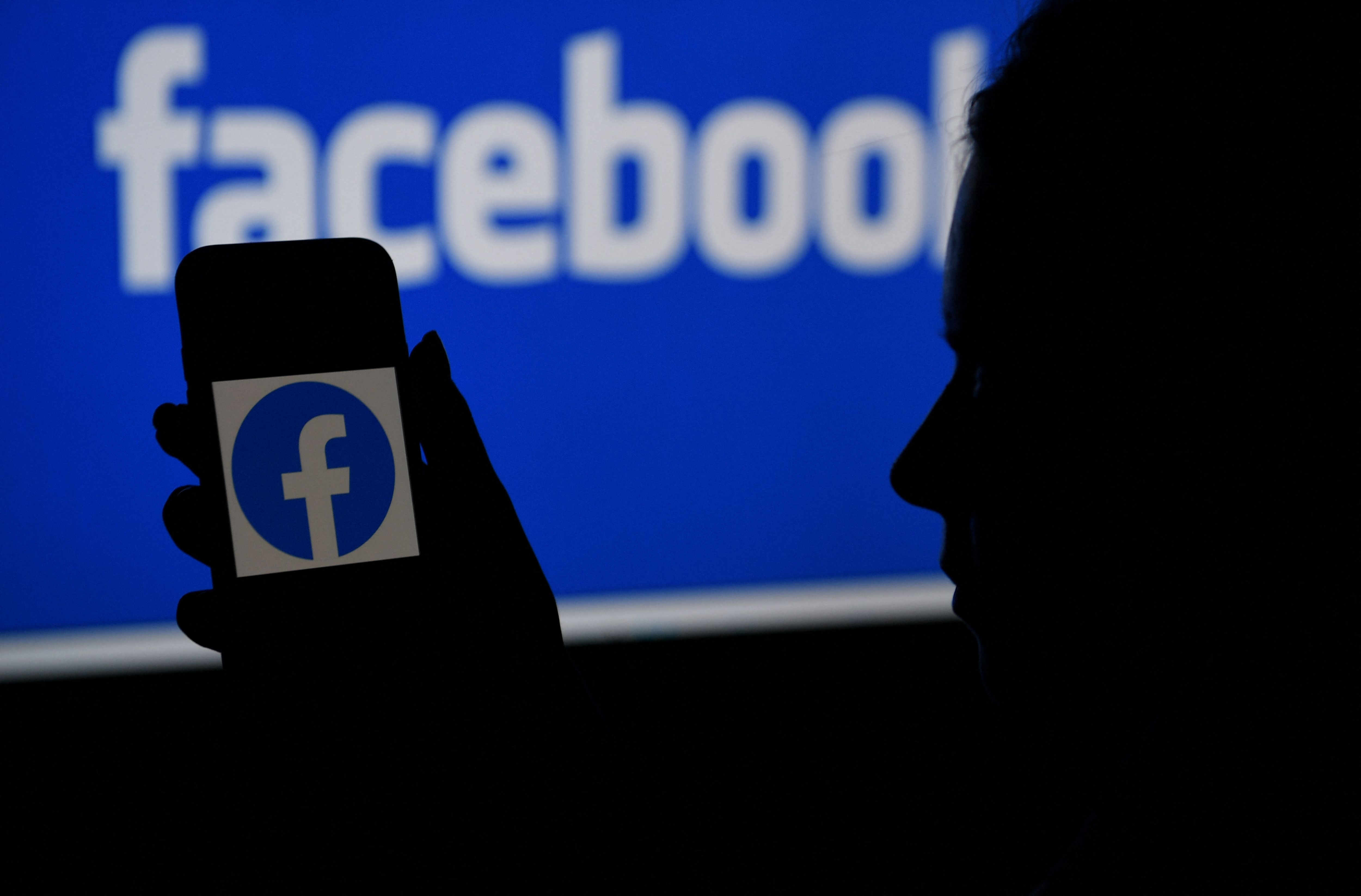 (FILES) In this file illustration photo taken on April 7, 2021, a smart phone screen displays the logo of Facebook on a Facebook website background, in Arlington, Virginia. - A Facebook test of pop-up boxes asking people whether they think friends are becoming extremists raised concerns on July 2, 2021 among US conservatives who felt their voices might be stifled. (Photo by OLIVIER DOULIERY / AFP)