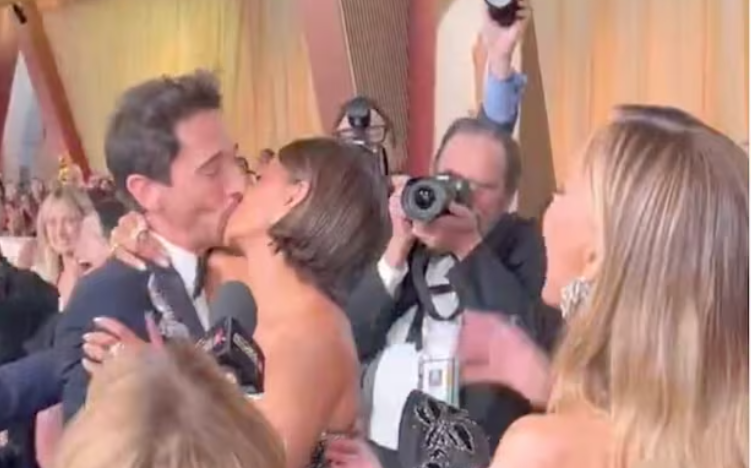 Halle Berry y Adrien Brody dándose un beso.