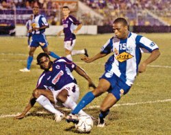 El zaguero morado Jervis Drummond barre al catracho José Grant anoche en La Ceiba. | LA PRENSA (HONDURAS)/PARA LN