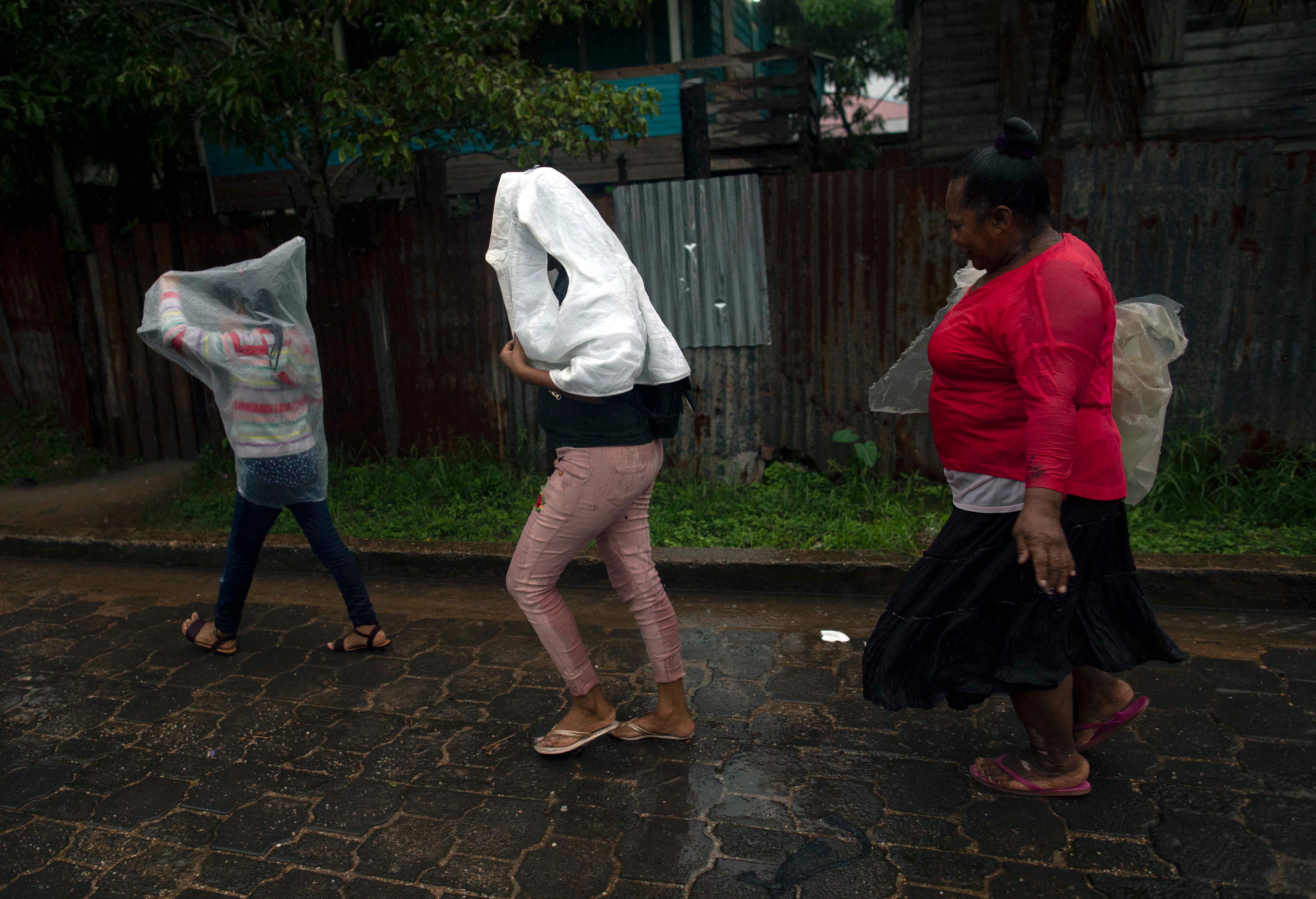 People walk to their houses on the beach as Hurricane Eta approaches in Bilwi, Puerto Cabezas, Nicaragua, on November 2, 2020. - Eta rapidly intensified to a Category 4 hurricane on Monday as it bore down on the Caribbean coast of Nicaragua and Honduras, threatening the Central American countries with catastrophic winds and floods. (Photo by INTI OCON / AFP)