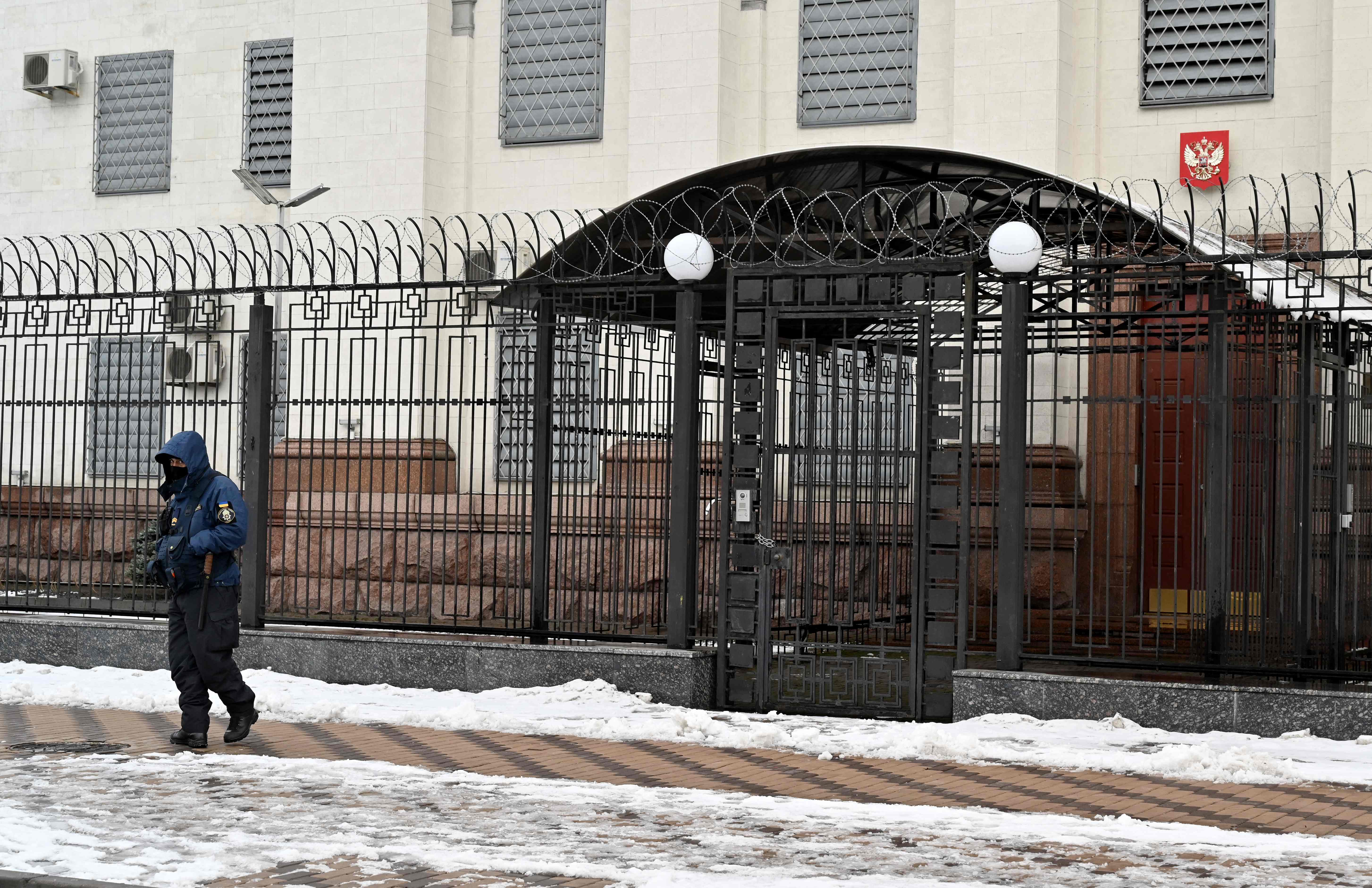 A security officer stays in guard at Russian embassy in Kyiv on February 12, 2022. - Russia said February 12, 2022, it has pulled some of its diplomatic staff out of Ukraine for fear of "provocations" from Kyiv or its allies amid mounting warnings of a possible Russian invasion of its neighbour. "Fearing possible provocations from the Kyiv regime or other. (Photo by Sergei SUPINSKY / AFP)