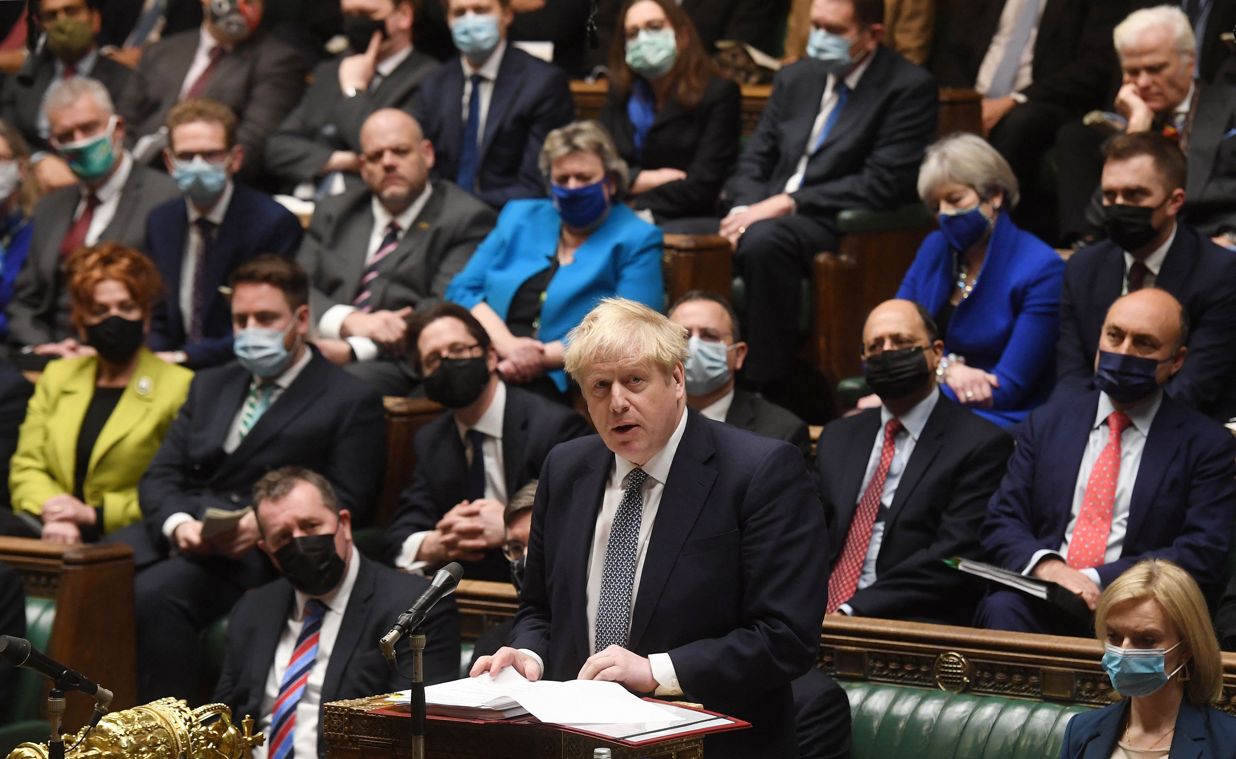 A handout photograph released by the UK Parliament shows Britain's Prime Minister Boris Johnson attending Prime Minister's Questions (PMQs) in the House of Commons in London on January 12, 2022. - UK Prime Minister Boris Johnson Wednesday apologised for attending a lockdown-breaching party held in his Downing Street garden, but deflected calls to resign as the opposition leader called him a "man without shame". After days of dismal headlines and collapsing poll ratings, Johnson said he regarded the newly revealed boozy get-together in May 2020 as a work event for Downing Street staff. (Photo by JESSICA TAYLOR / various sources / AFP) / RESTRICTED TO EDITORIAL USE - NO USE FOR ENTERTAINMENT, SATIRICAL, ADVERTISING PURPOSES - MANDATORY CREDIT " AFP PHOTO / Jessica Taylor /UK Parliament"
