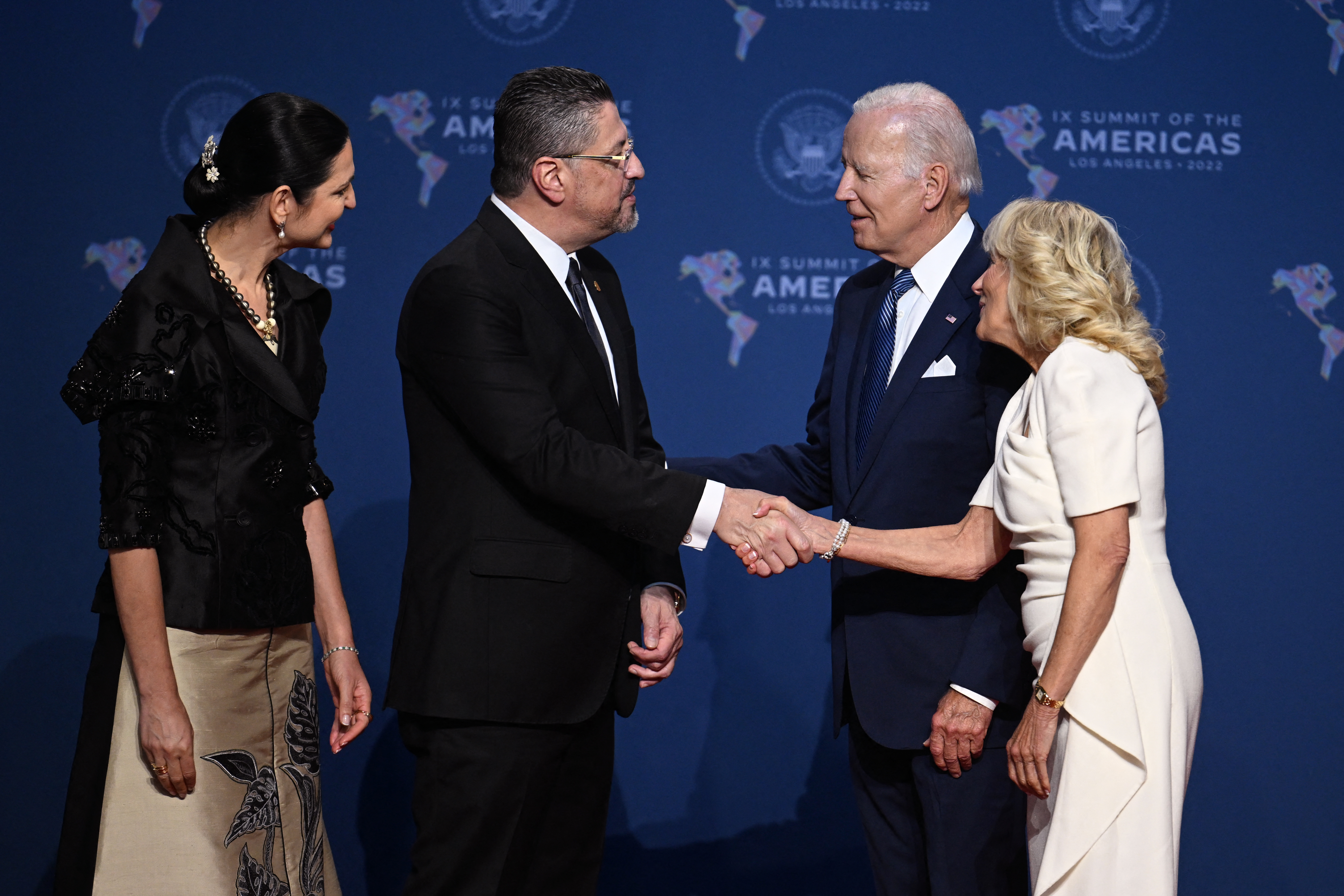 US President Joe Biden (2nd R) and First Lady Jill Biden (R) greet President of Costa Rica Rodrigo Chaves Robles (2nd L) and wife Signe Zeicate as they arrive for the 9th Summit of the Americas at the Los Angeles Convention Center in Los Angeles, California on June 8, 2022. (Photo by Jim WATSON / AFP)