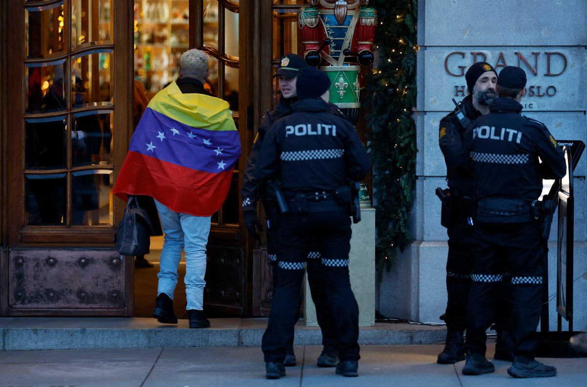Hombre envuelto con la bandera de Venezuela en el Grand Hotel en Oslo, Noruega, antes de la ceremonia del Nobel.