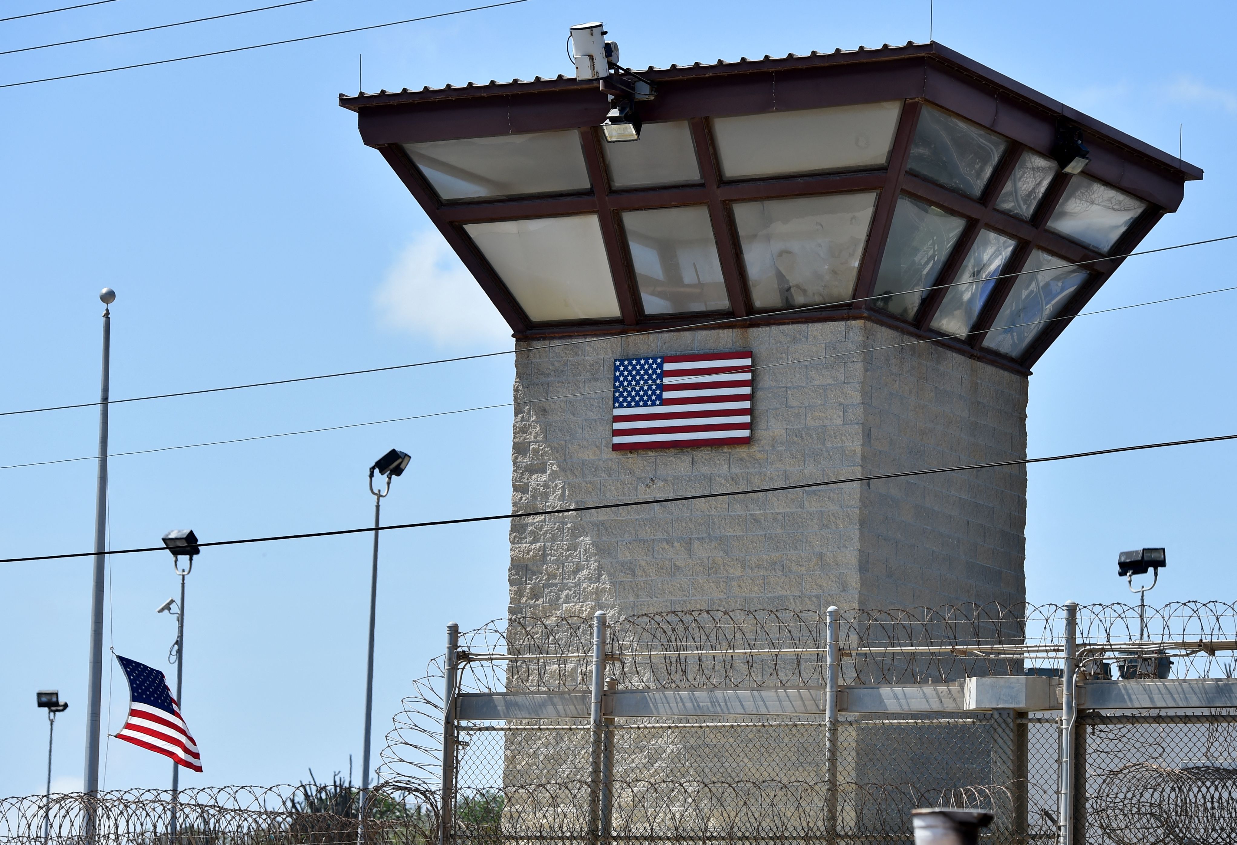 (FILES) In this file photo made during an escorted visit and reviewed by the US military shows the razor wire-topped fence and the watch tower of "Camp 6" detention facility at the US Naval Station in Guantanamo Bay, Cuba, April 8, 2014. - The prosecution of alleged September 11 mastermind Khalid Sheikh Mohammed and four others restarts on September 7, 2021, just days before the 20th anniversary of the attacks, stirring new hopes for justice and retribution. Mohammed and his co-defendants, who have been locked up at the "War on Terror" prison at the US naval base in Guantanamo Bay, Cuba for nearly 15 years, will appear in the military tribunal here for the first time since early 2019. (Photo by Mladen ANTONOV / AFP)