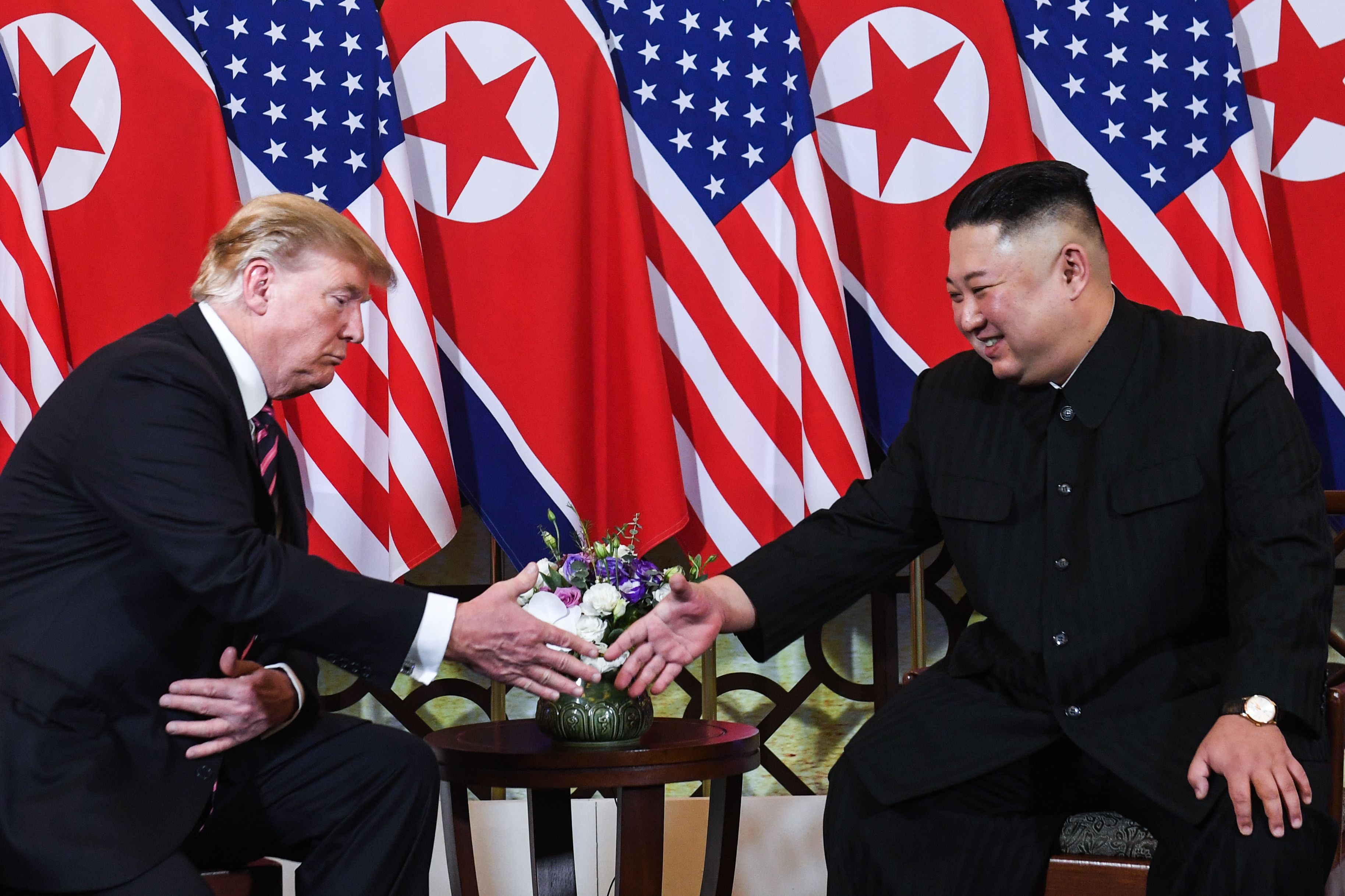 TOPSHOT - US President Donald Trump (L) shakes hands with North Korea's leader Kim Jong Un following a meeting at the Sofitel Legend Metropole hotel in Hanoi on February 27, 2019. (Photo by SAUL LOEB / AFP)