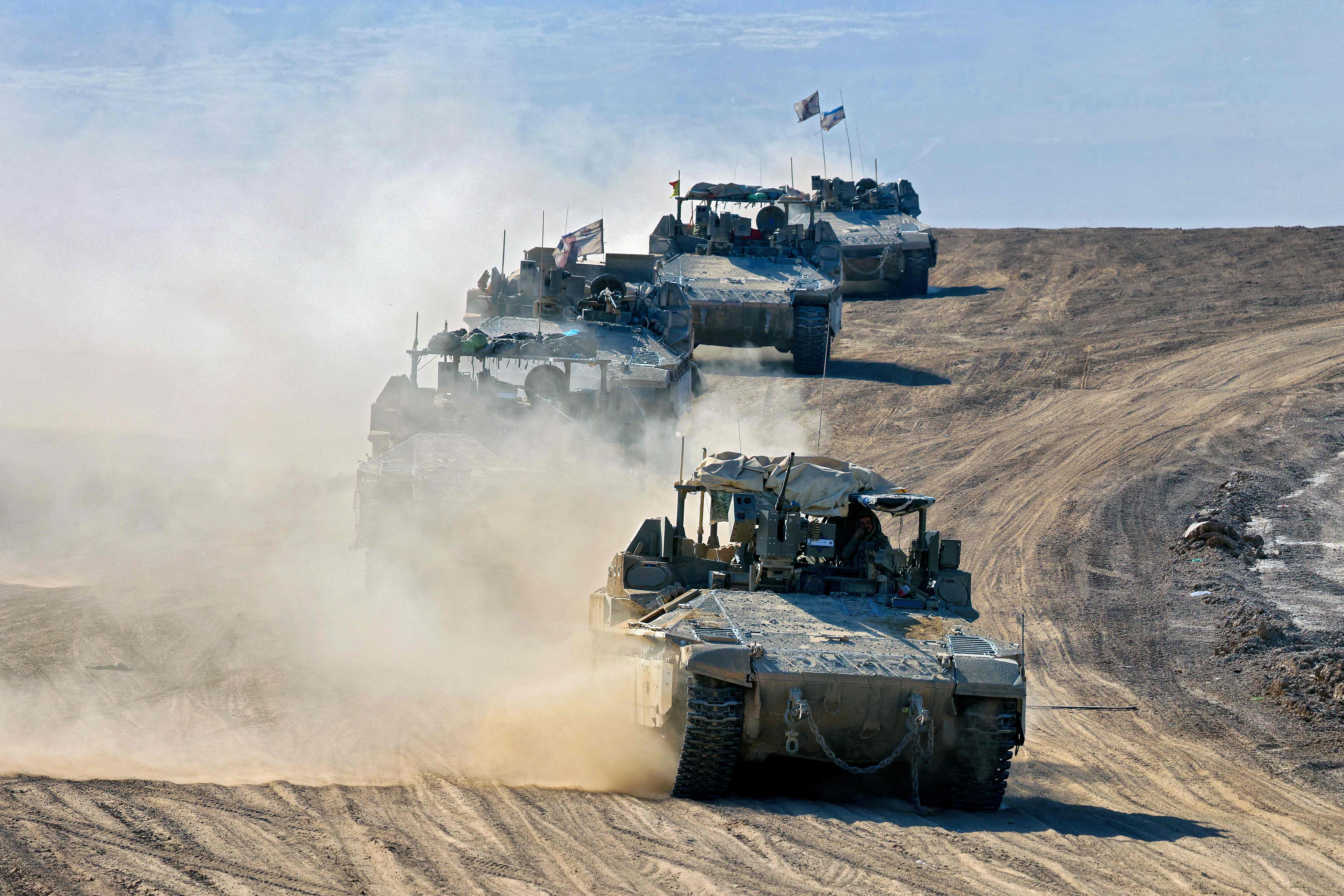 This picture taken from Israel's southern border with the Gaza Strip shows Israeli armoured vehicles rolling along the border with the Palestinian territory on April 17, 2024, amid the ongoing conflict between Israel and the militant group Hamas. (Photo by JACK GUEZ / AFP)