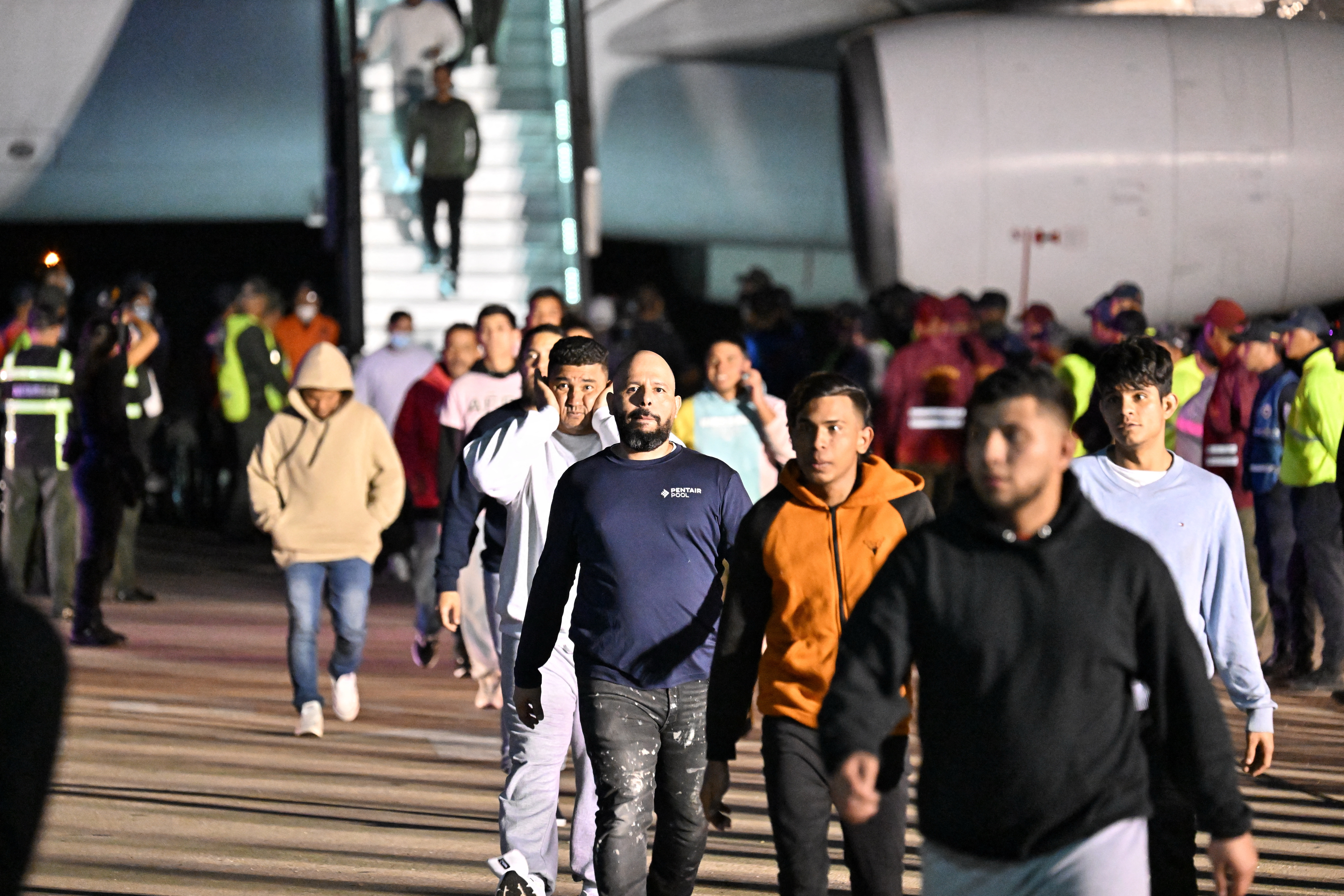 Venezuelan migrants deported from the United States and stranded in Honduras disembark from a Conviasa Airlines plane upon arrival at Simon Bolivar International Airport in Maiquetia, Venezuela on March 24, 2025. (Photo by JUAN BARRETO / AFP)